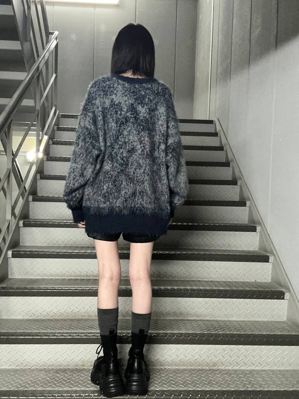 ブラック系のブーツ、ブルー系のニット/セーター、ブラック系のその他パンツを着用したレディースの秋コーディネートの4枚目の写真