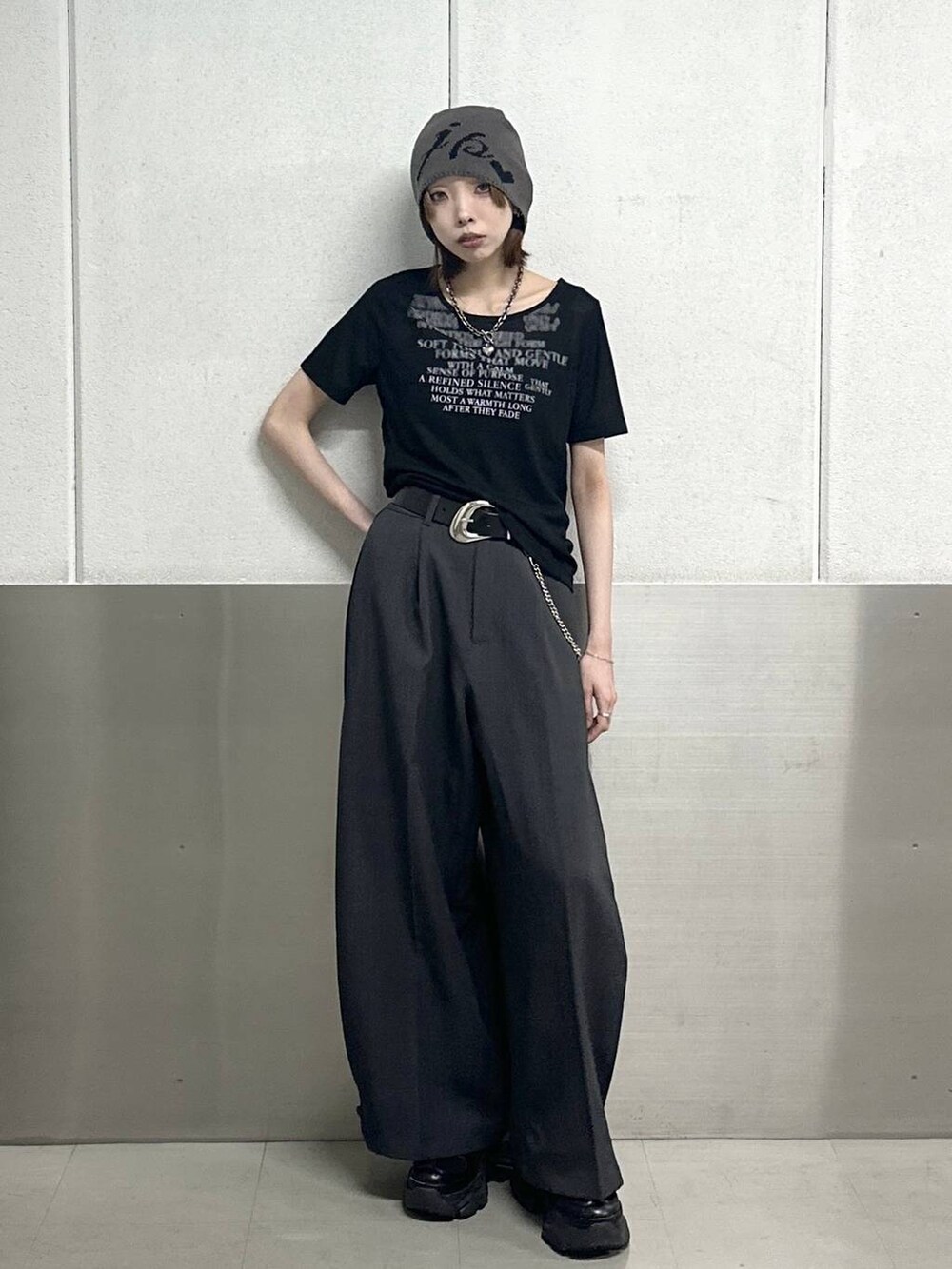 ブラック系のスニーカー、グレー系のスラックス、ブラック系のTシャツ/カットソーを着用したレディースの春コーディネートの2枚目の写真
