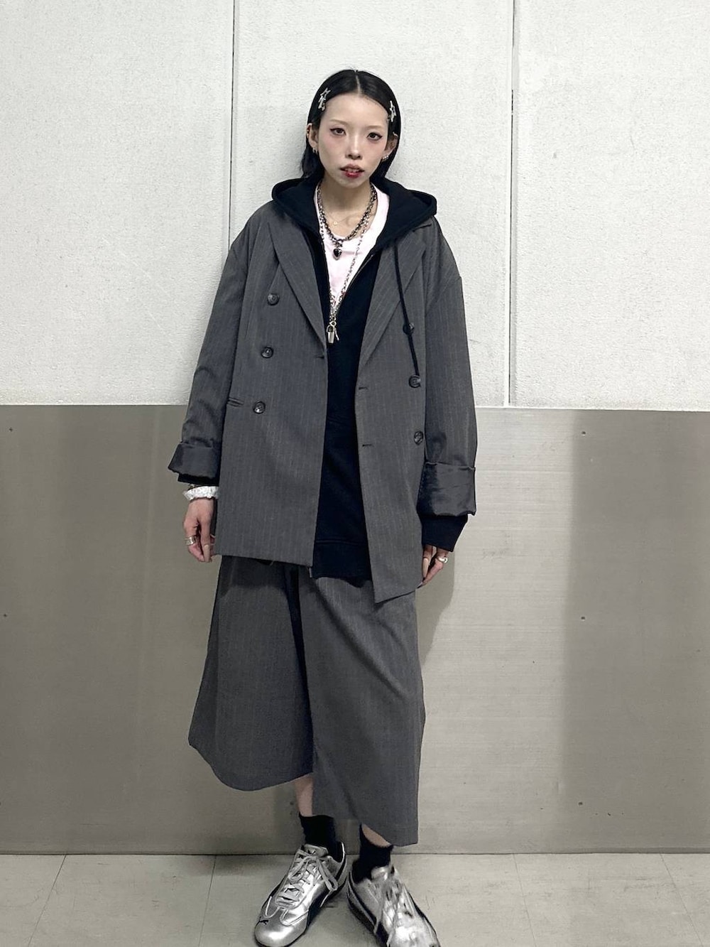 ブラック系のパーカー、ピンク系のTシャツ/カットソー、グレー系のテーラードジャケットを着用したレディースの春コーディネートの2枚目の写真