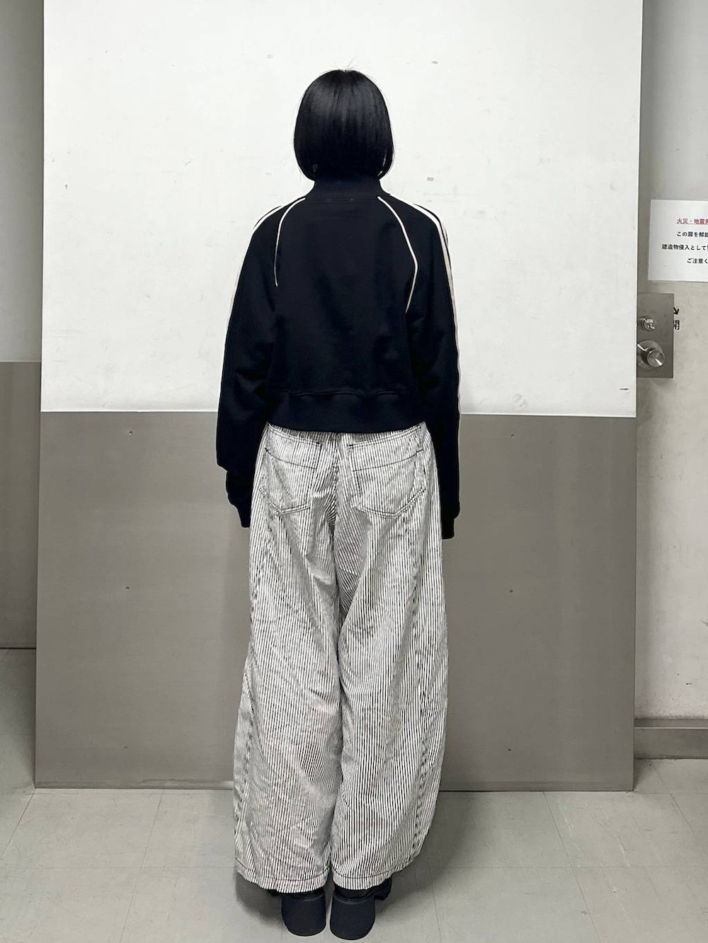 ブラック系のブーツ、ブラック系のデニムパンツ、ブラック系のジャージを着用したレディースの冬コーディネートの4枚目の写真