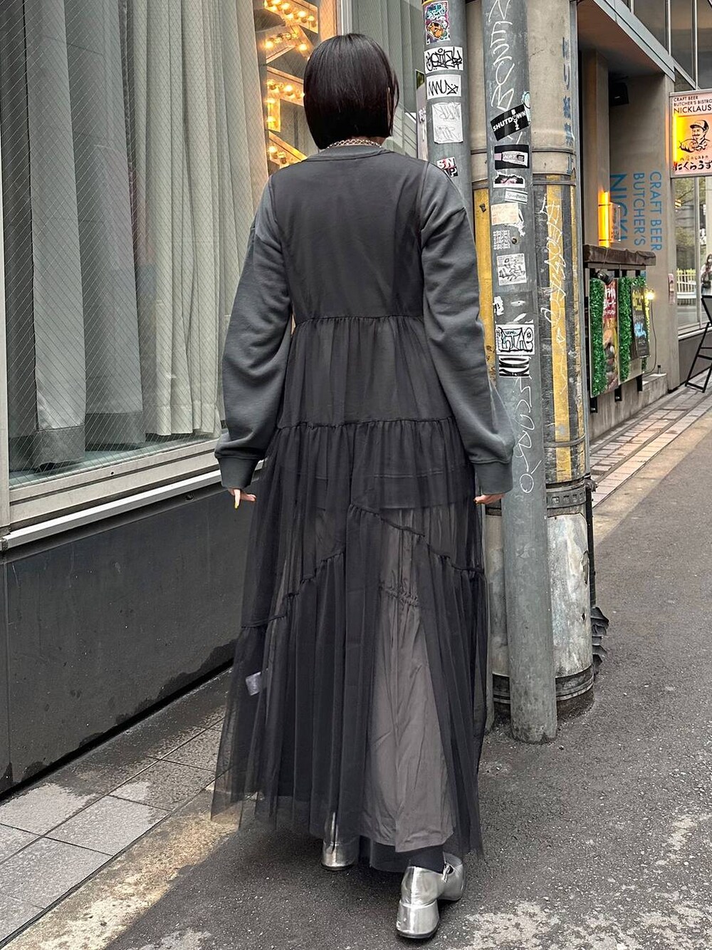 グレー系のスカート、ブラック系のワンピース、ブラック系のスウェットを着用したレディースの春コーディネートの3枚目の写真