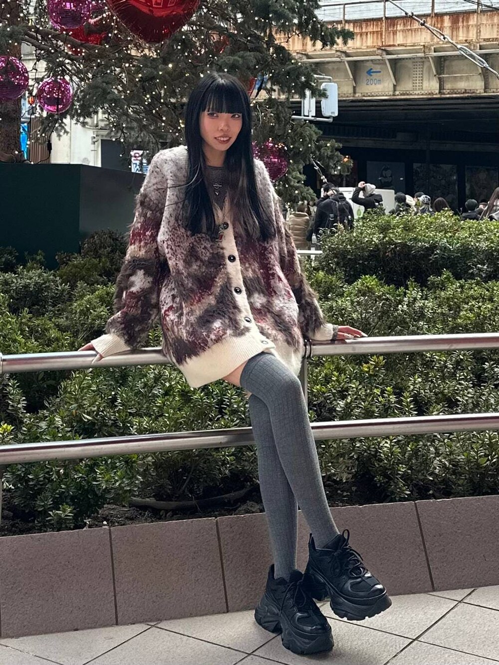 ブラック系のスニーカー、ブラウン系のTシャツ/カットソー、ホワイト系のカーディガン/ボレロを着用したレディースの冬コーディネートの3枚目の写真