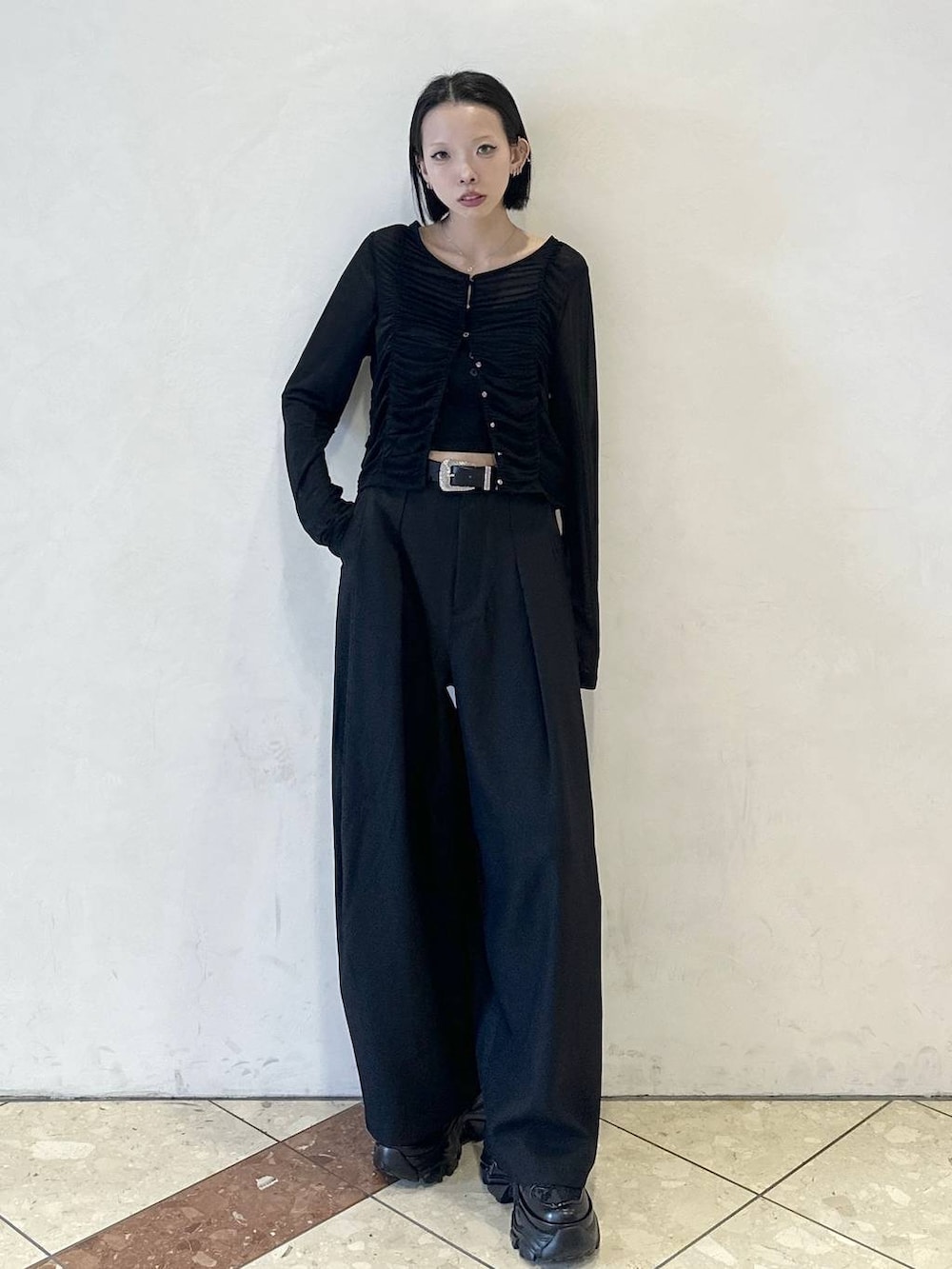 ブラック系のスニーカー、ブラック系のスラックス、ブラック系のTシャツ/カットソーを着用したレディースの春コーディネートの2枚目の写真