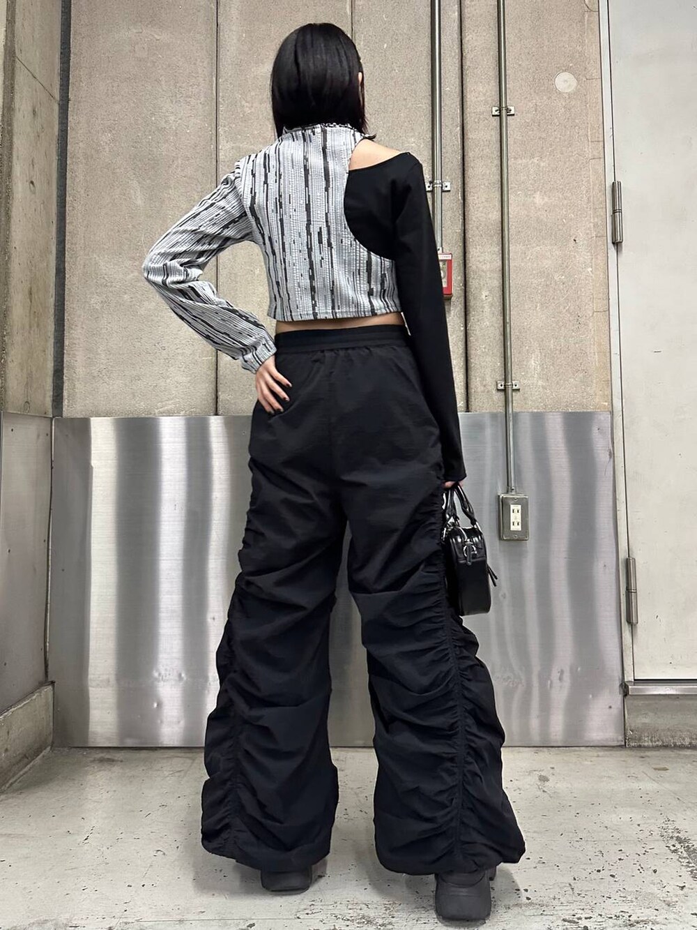 ブラック系のその他パンツ、ブラック系のブーツ、ブラック系のボストンバッグを着用したレディースの冬コーディネートの4枚目の写真