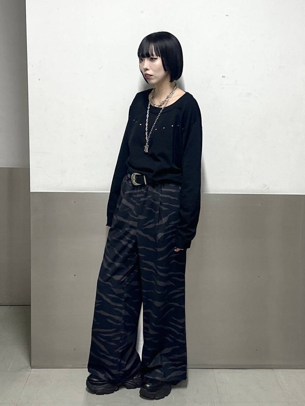 ブラック系のスニーカー、ブラック系のニット/セーター、その他のスラックスを着用したレディースの冬コーディネートの3枚目の写真