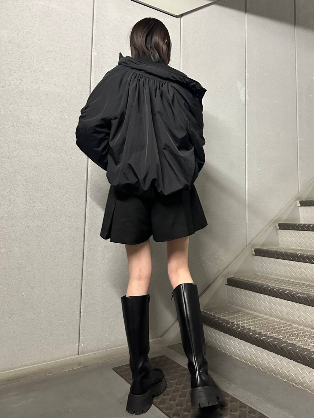 ブラック系のブーツ、ブラック系のニット/セーター、ブラック系のその他パンツを着用したレディースの冬コーディネートの4枚目の写真