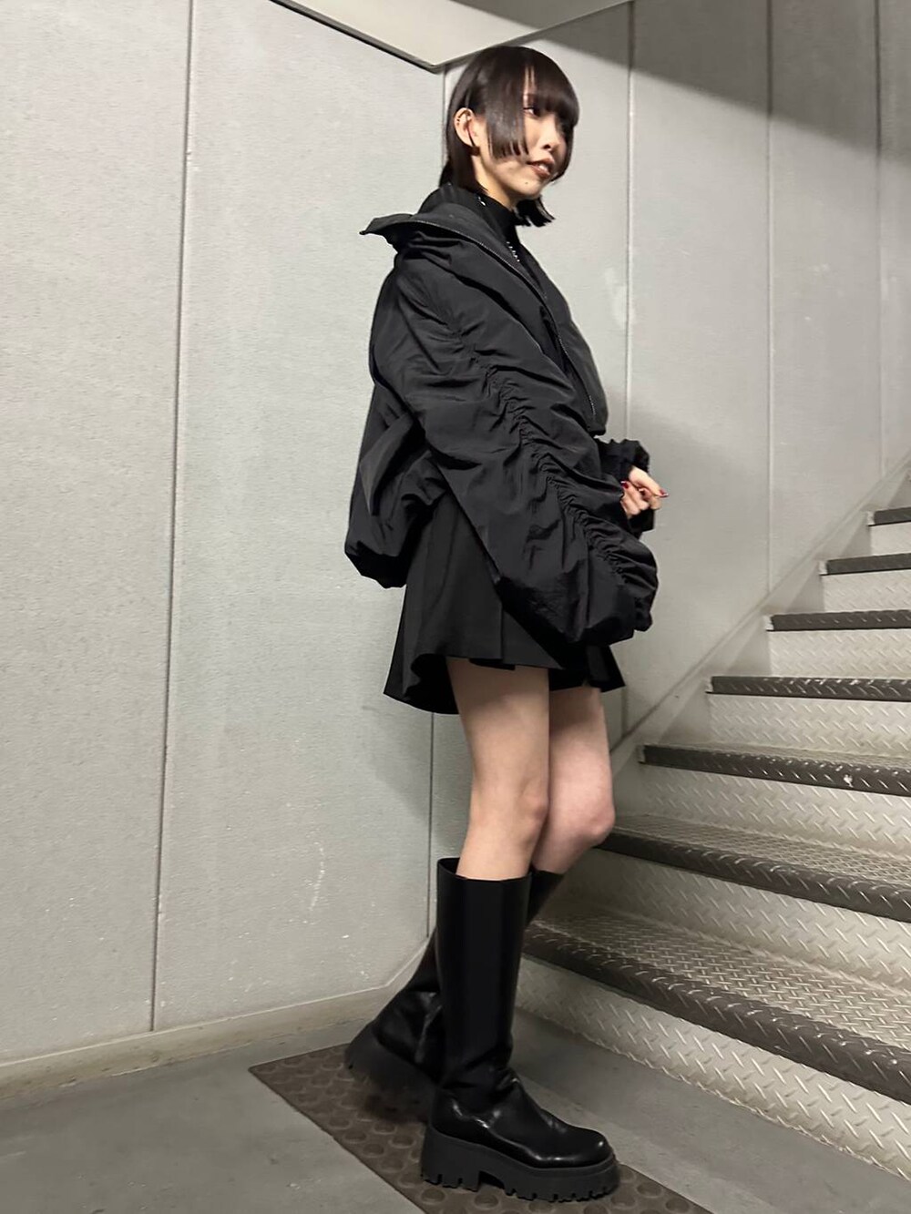 ブラック系のブーツ、ブラック系のニット/セーター、ブラック系のその他パンツを着用したレディースの冬コーディネートの3枚目の写真