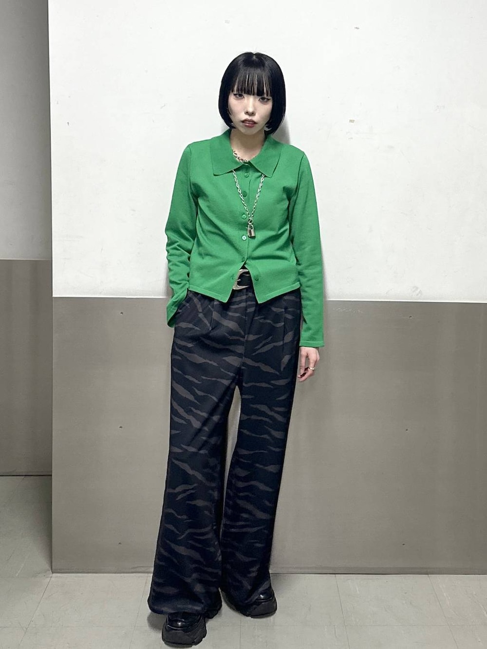 ブラック系のスニーカー、グリーン系のカーディガン/ボレロ、その他のスラックスを着用したレディースの冬コーディネートの2枚目の写真