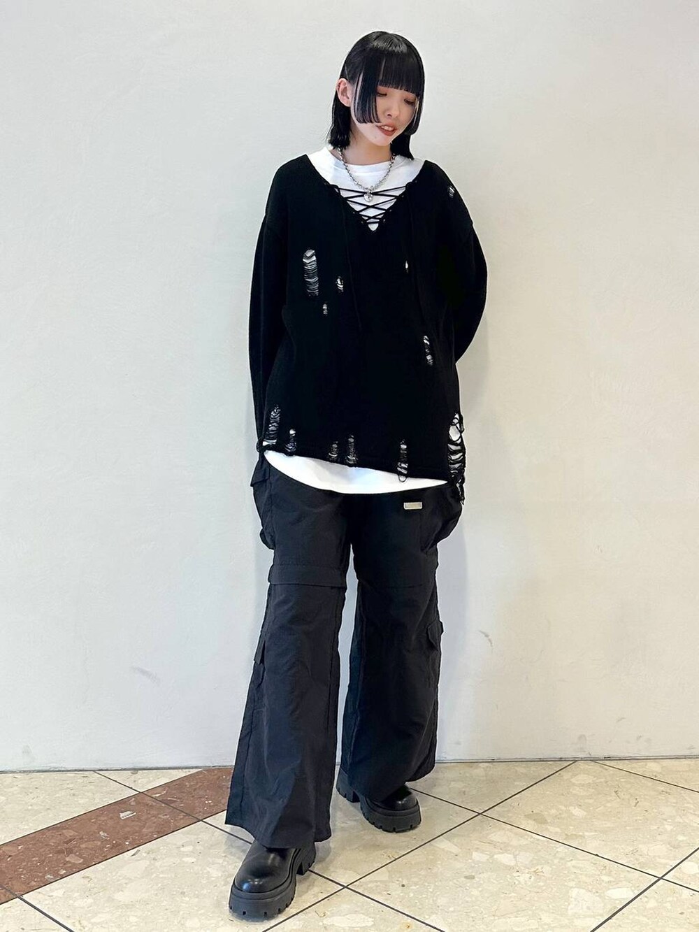 ブラック系のニット/セーター、ブラック系のカーゴパンツ、ブラック系のブーツを着用したレディースの冬コーディネートの2枚目の写真