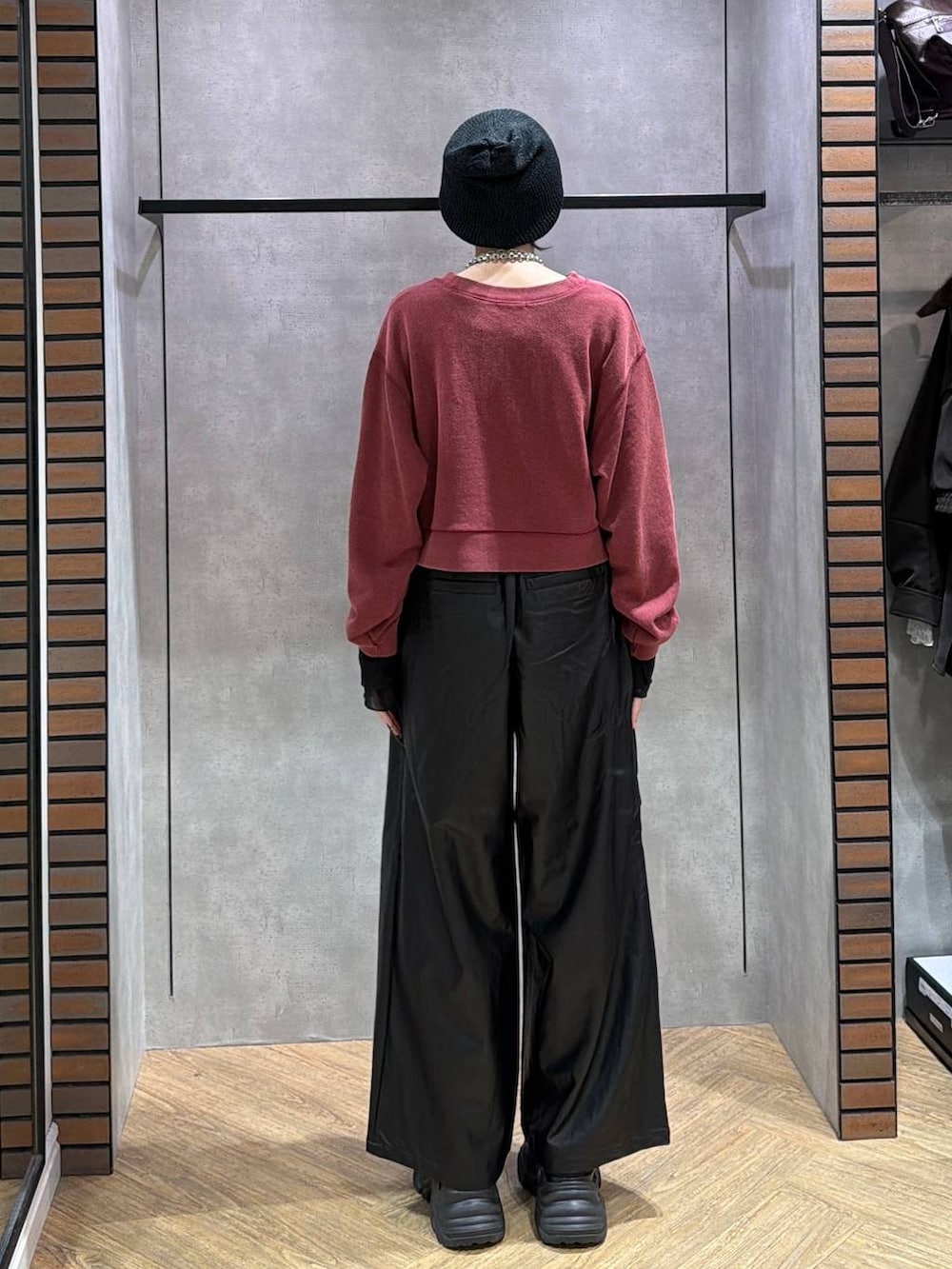 レッド系のスウェット、ブラック系のスニーカー、ブラック系のスラックスを着用したレディースの秋コーディネートの4枚目の写真
