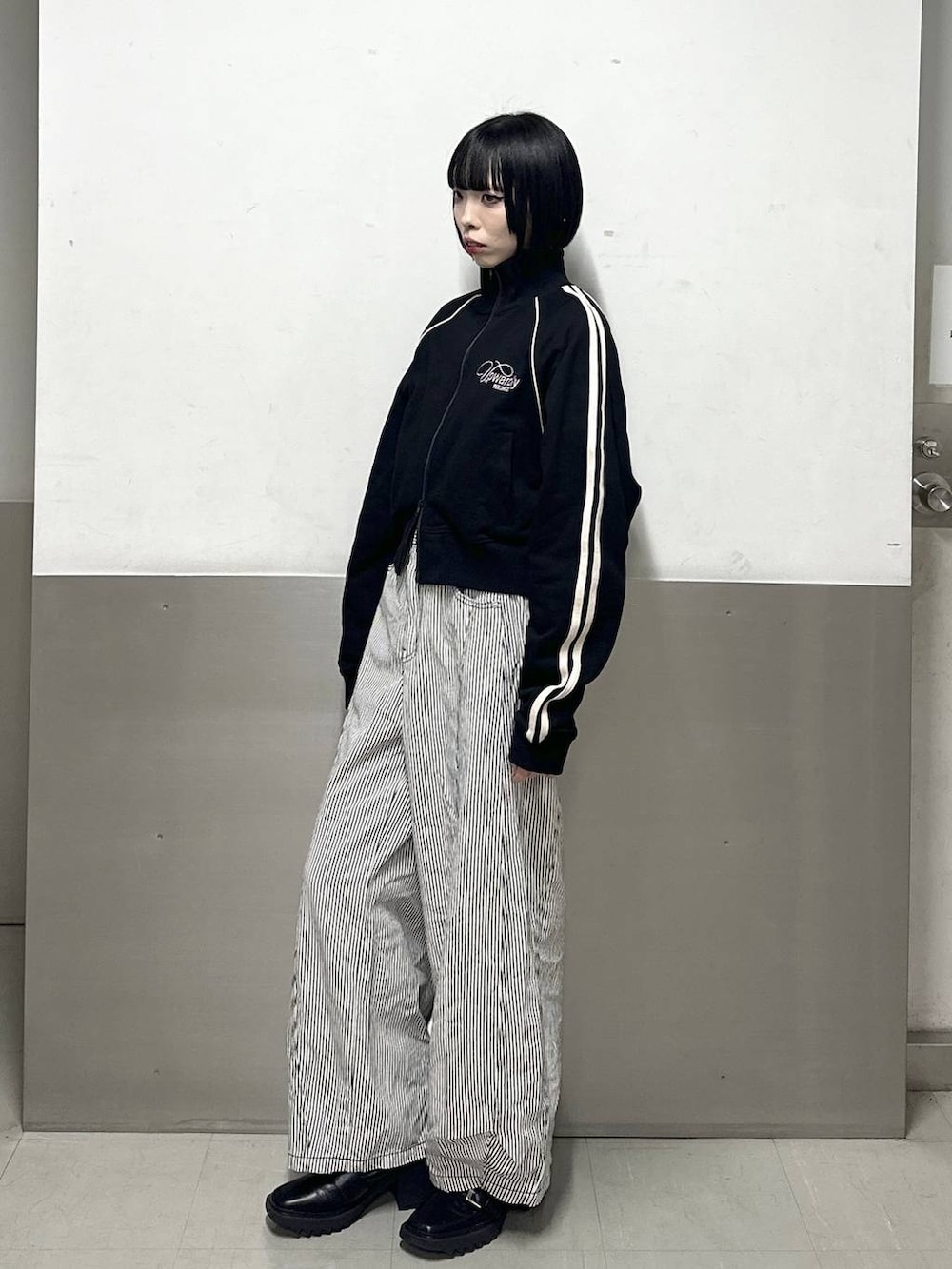 ブラック系のブーツ、ブラック系のデニムパンツ、ブラック系のジャージを着用したレディースの冬コーディネートの3枚目の写真