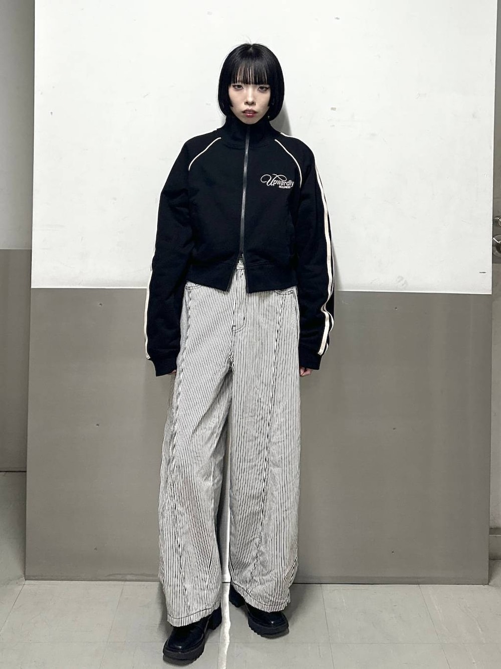 ブラック系のブーツ、ブラック系のデニムパンツ、ブラック系のジャージを着用したレディースの冬コーディネートの2枚目の写真