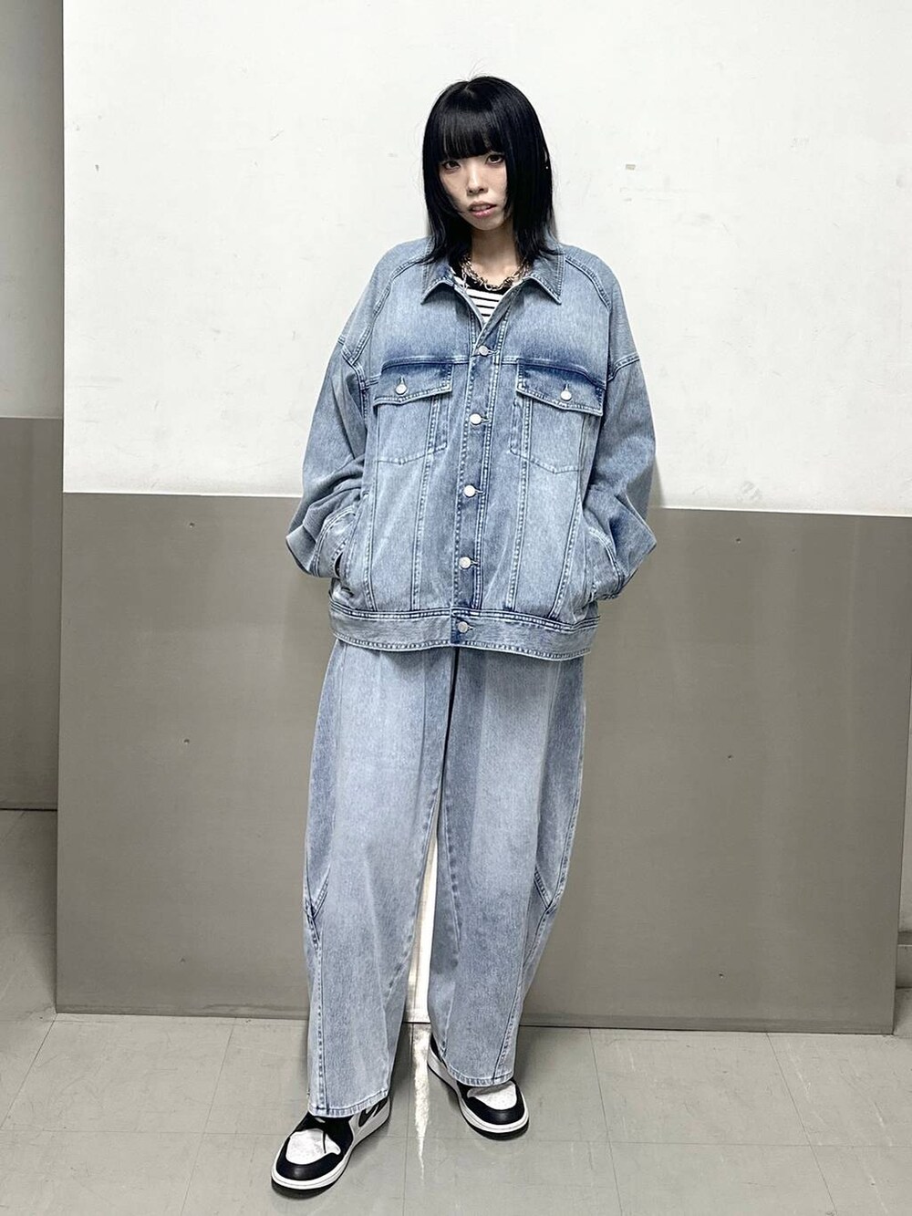 ブルー系のブルゾン、ホワイト系のニット/セーター、ブルー系のデニムパンツを着用したレディースの冬コーディネートの2枚目の写真