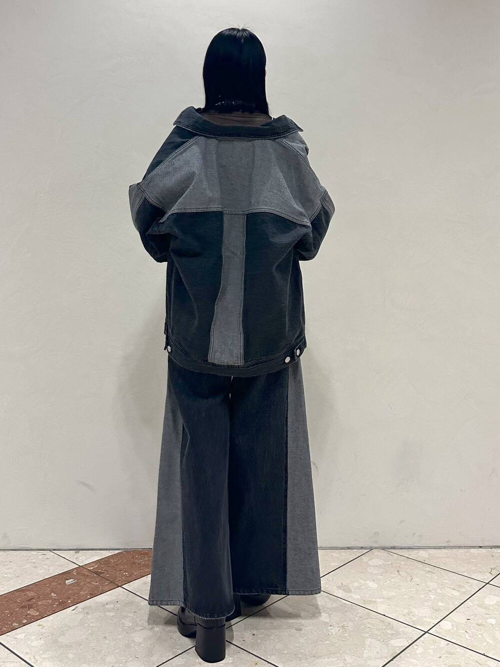 ブラック系のTシャツ/カットソー、ブラック系のデニムジャケット、ブラック系のブーツを着用したレディースの冬コーディネートの4枚目の写真