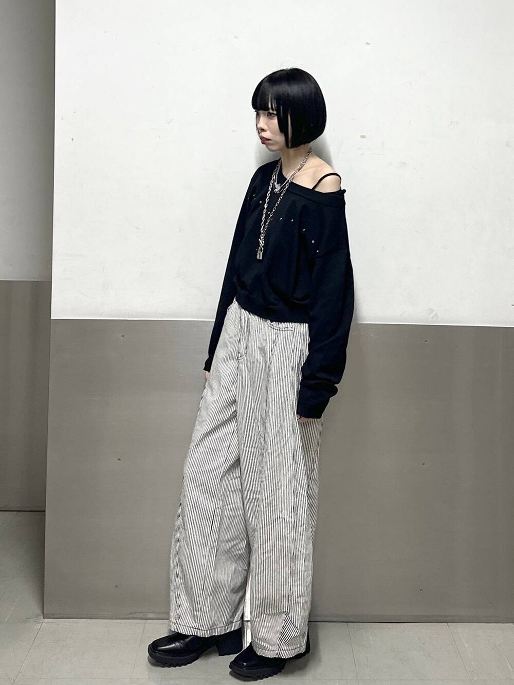 ブラック系のブーツ、ブラック系のニット/セーター、ブラック系のデニムパンツを着用したレディースの冬コーディネートの3枚目の写真