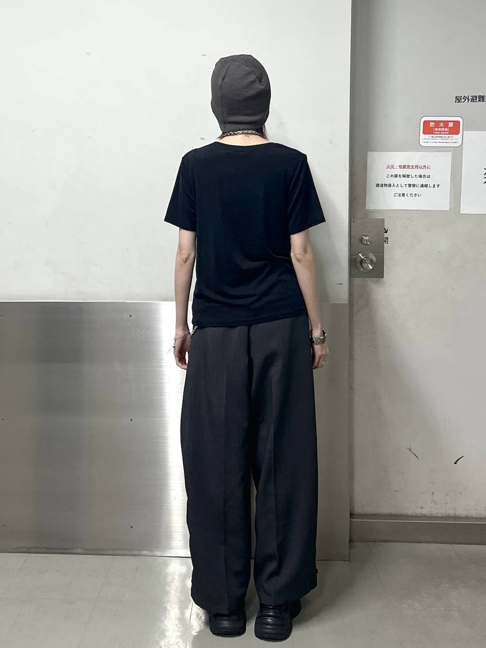 ブラック系のスニーカー、グレー系のスラックス、ブラック系のTシャツ/カットソーを着用したレディースの春コーディネートの4枚目の写真