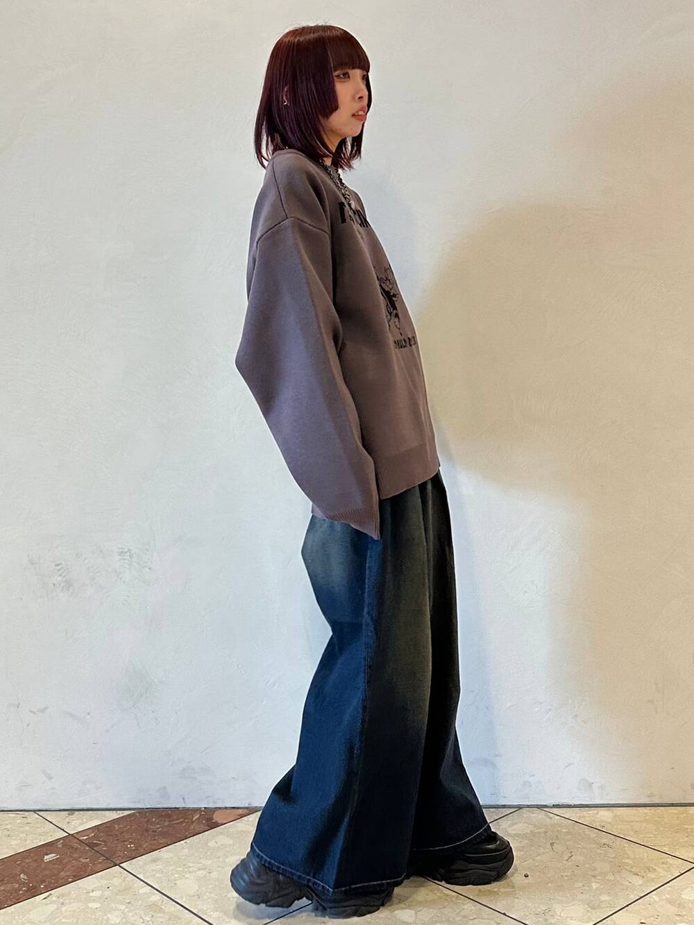 ブラック系のスニーカー、ブルー系のデニムパンツ、グレー系のニット/セーターを着用したレディースの冬コーディネートの3枚目の写真