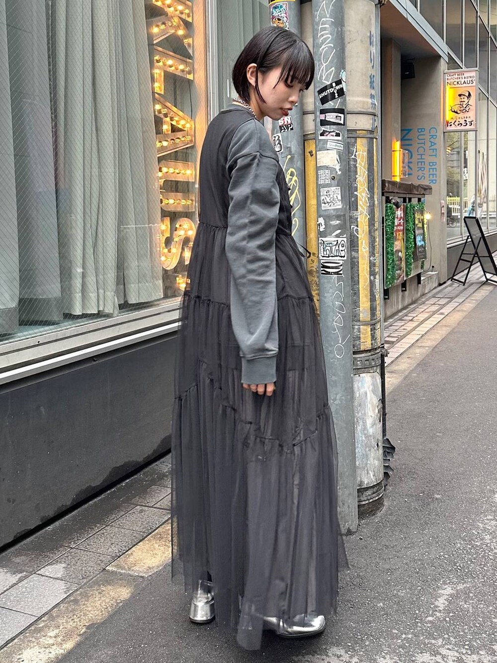 グレー系のスカート、ブラック系のワンピース、ブラック系のスウェットを着用したレディースの春コーディネートの2枚目の写真