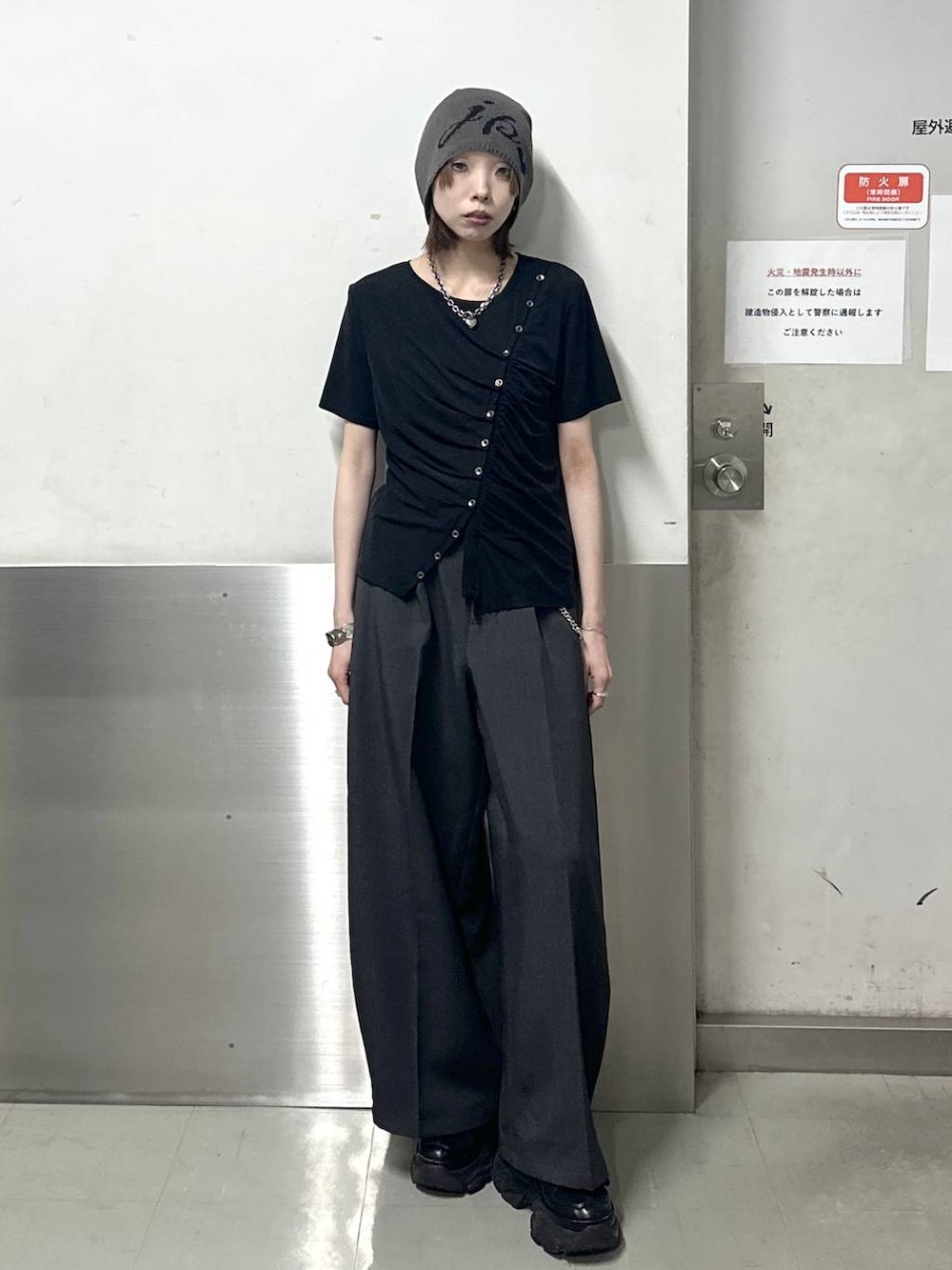ブラック系のスニーカー、グレー系のスラックス、ブラック系のTシャツ/カットソーを着用したレディースの春コーディネートの2枚目の写真