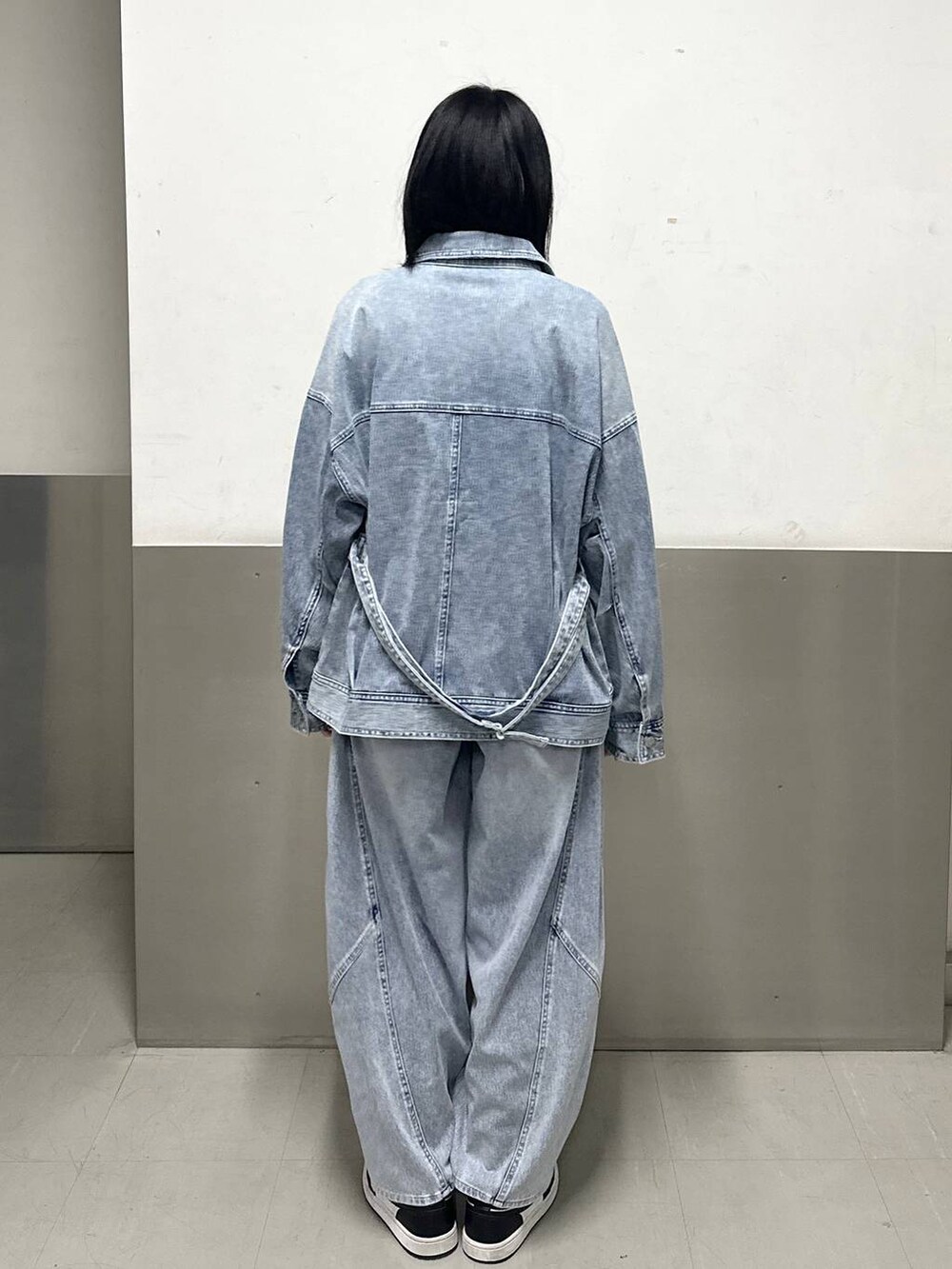 ブルー系のブルゾン、ホワイト系のニット/セーター、ブルー系のデニムパンツを着用したレディースの冬コーディネートの4枚目の写真