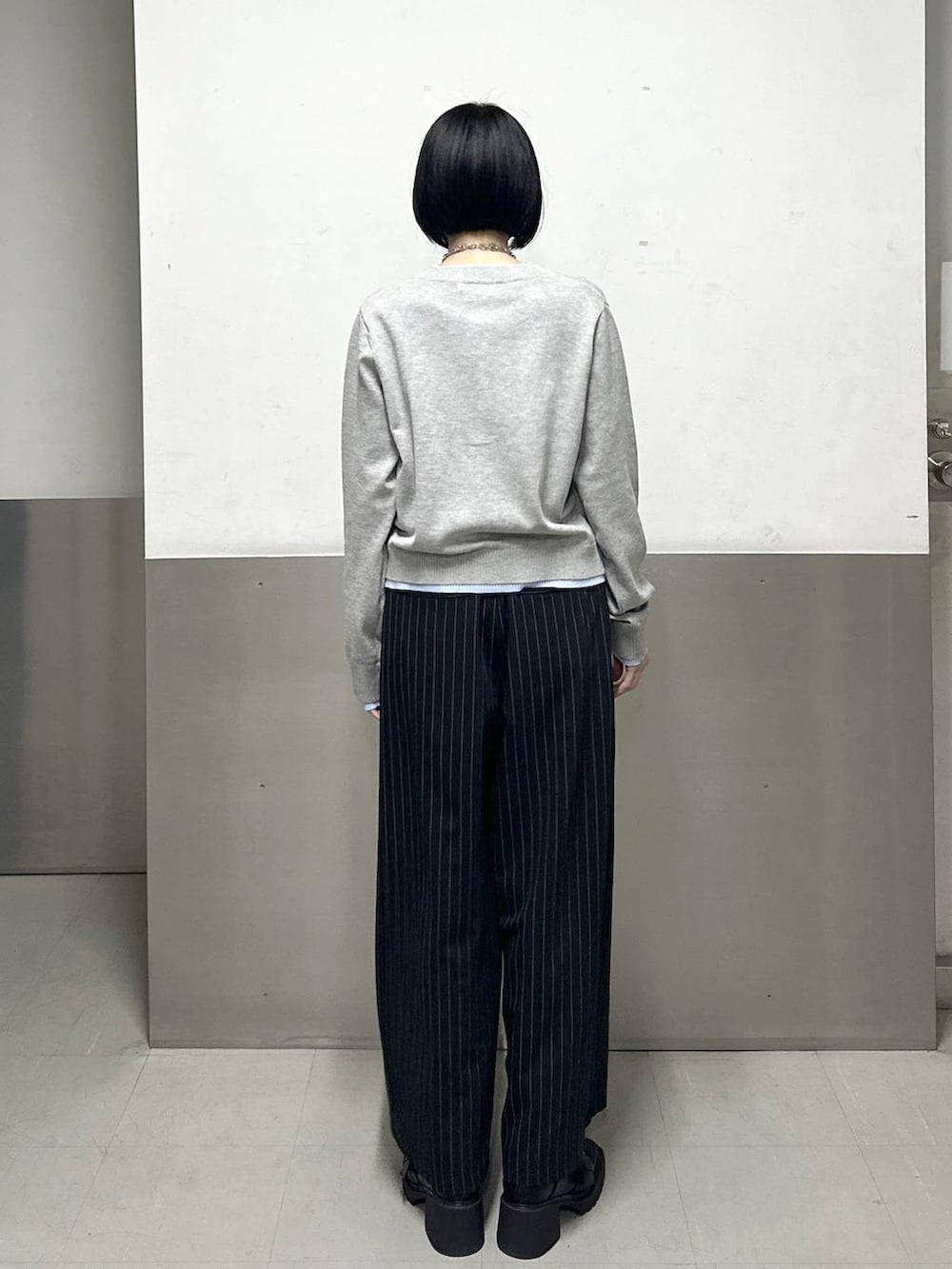 ブラック系のブーツ、ブラック系のスラックス、グレー系のカーディガン/ボレロを着用したレディースの冬コーディネートの4枚目の写真