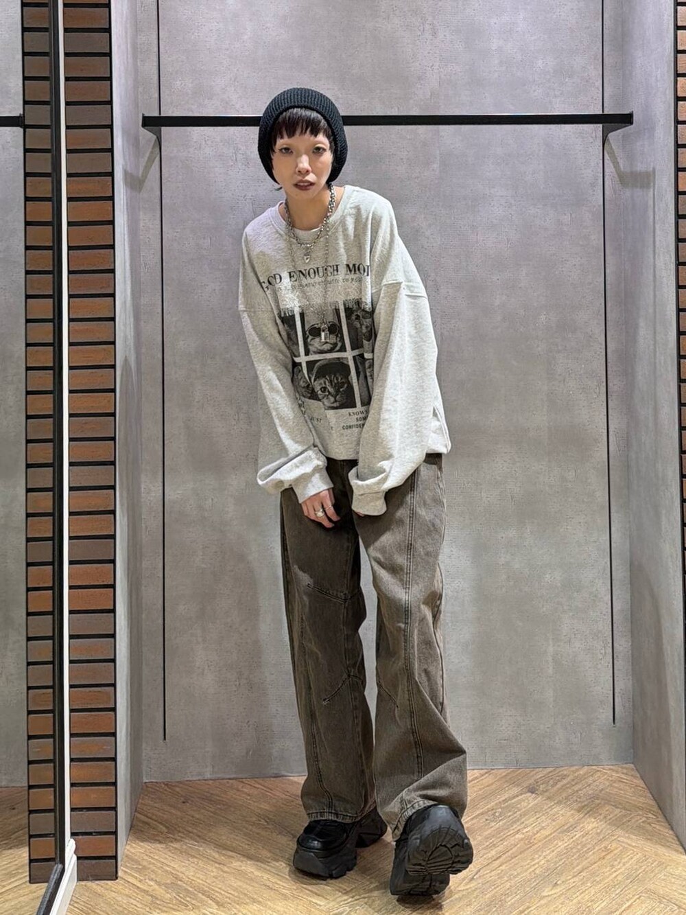 ブラウン系のデニムパンツ、ブラック系のスニーカー、グレー系のスウェットを着用したレディースの秋コーディネートの2枚目の写真