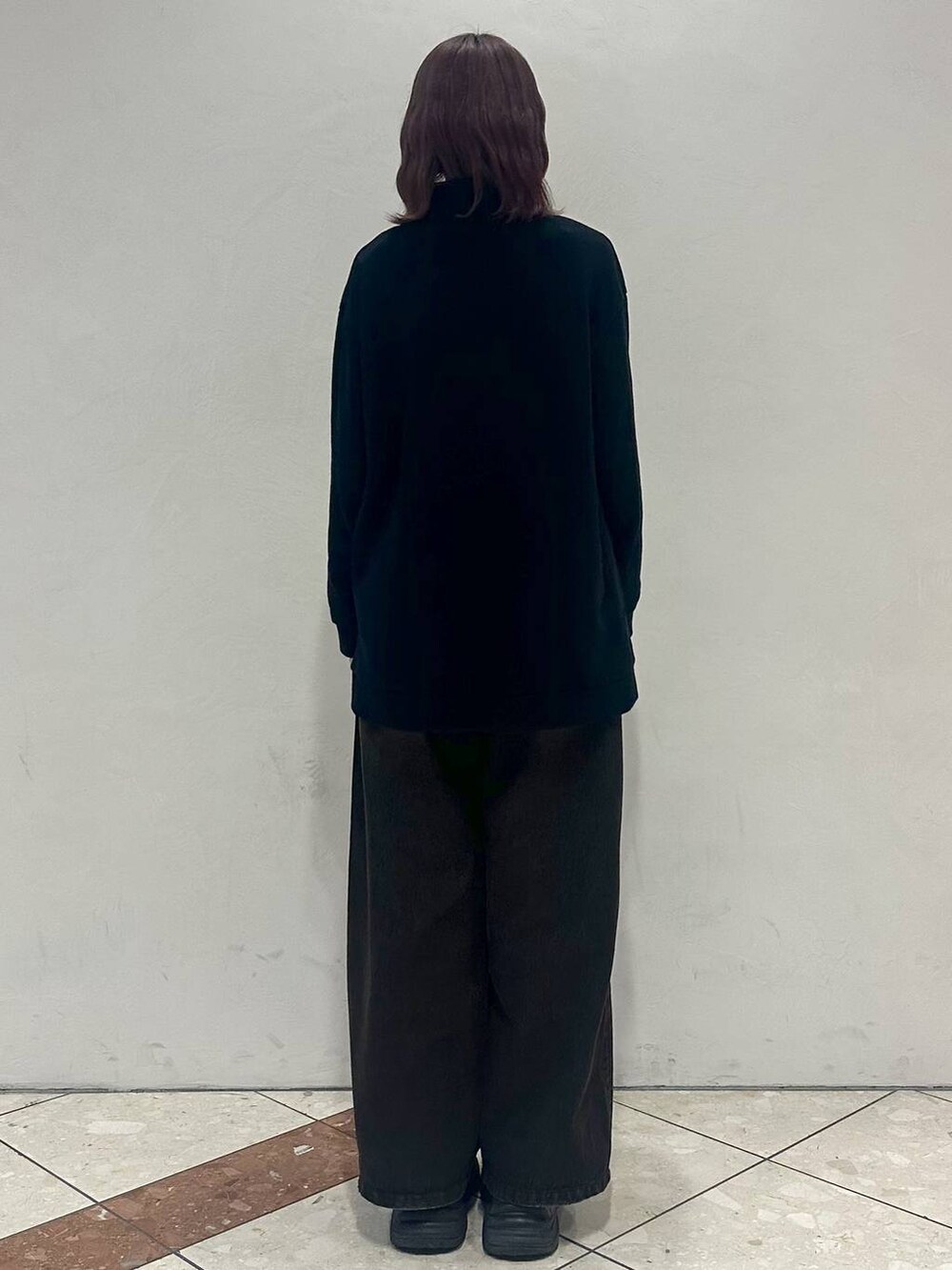 ブラック系のスニーカー、ブラック系のスウェット、ブラック系のデニムパンツを着用したレディースの冬コーディネートの4枚目の写真