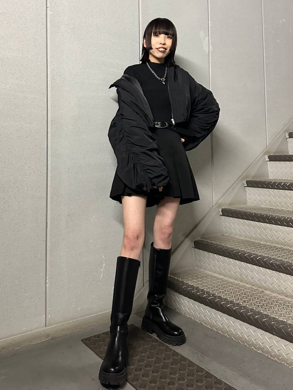 ブラック系のブーツ、ブラック系のニット/セーター、ブラック系のその他パンツを着用したレディースの冬コーディネートの2枚目の写真