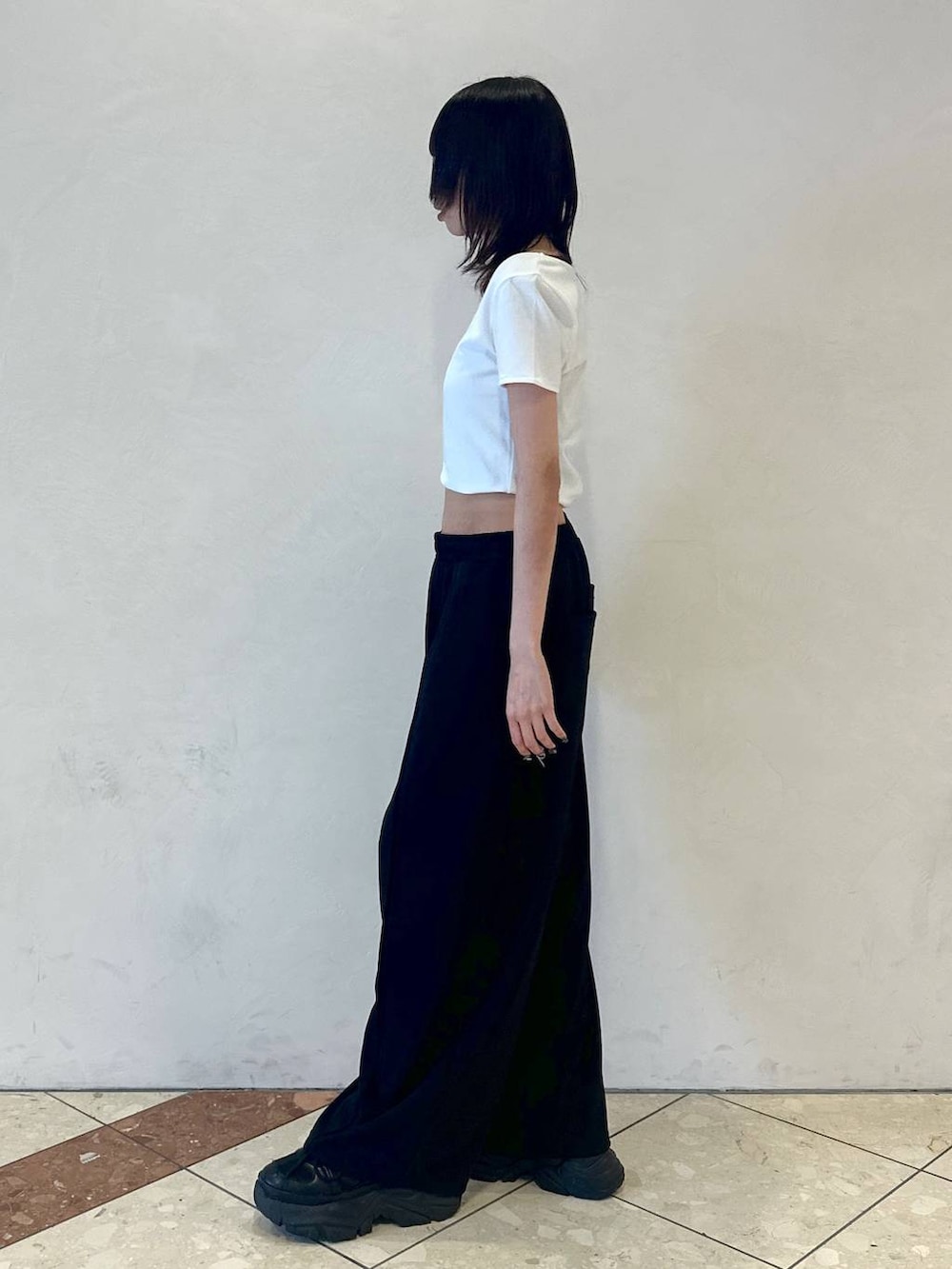 ブラック系のスニーカー、ホワイト系のTシャツ/カットソー、ブラック系のその他パンツを着用したレディースの夏コーディネートの3枚目の写真