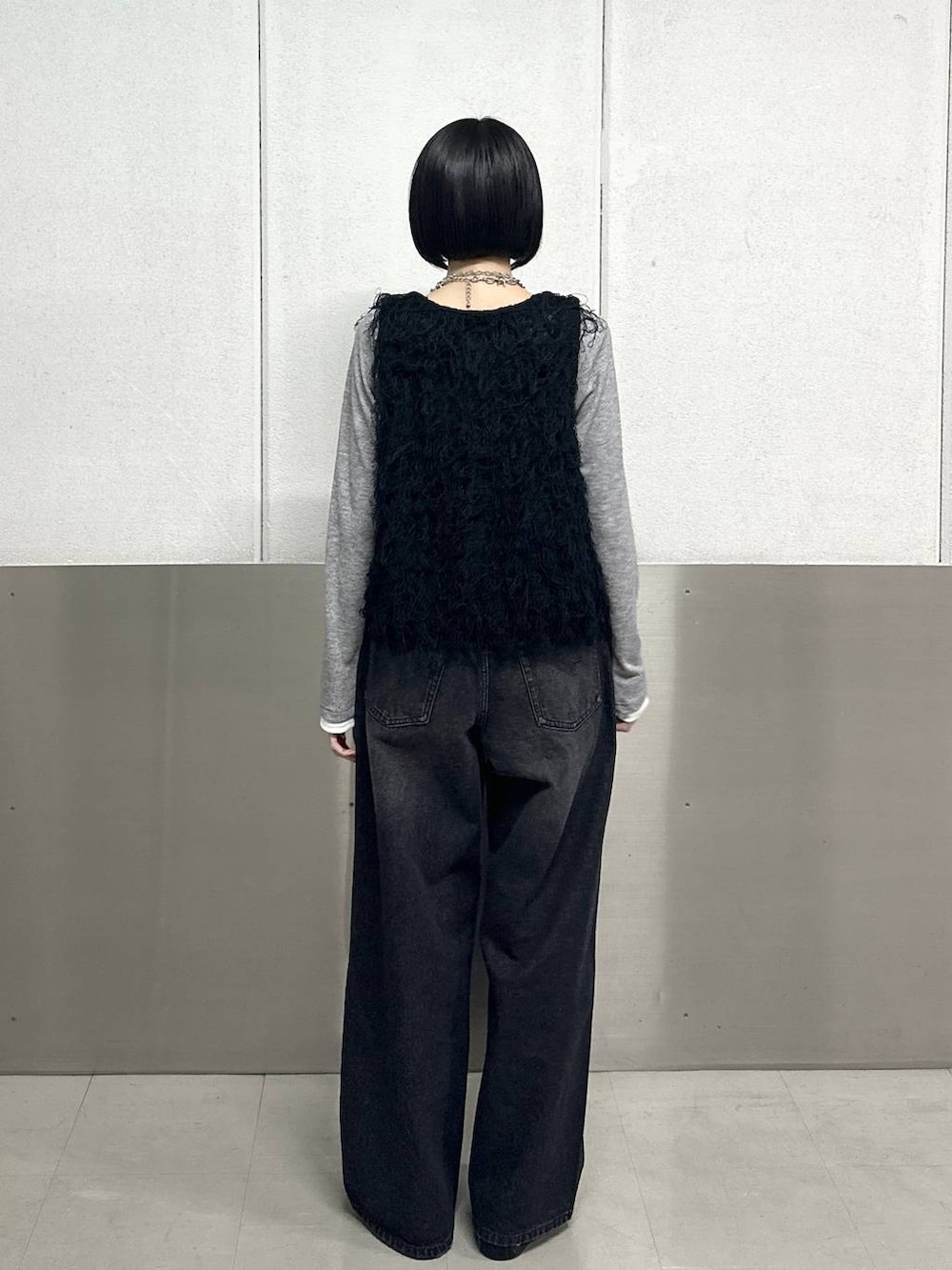 ブラック系のスラックス、ブラック系のベスト、グレー系のTシャツ/カットソーを着用したレディースの春コーディネートの4枚目の写真