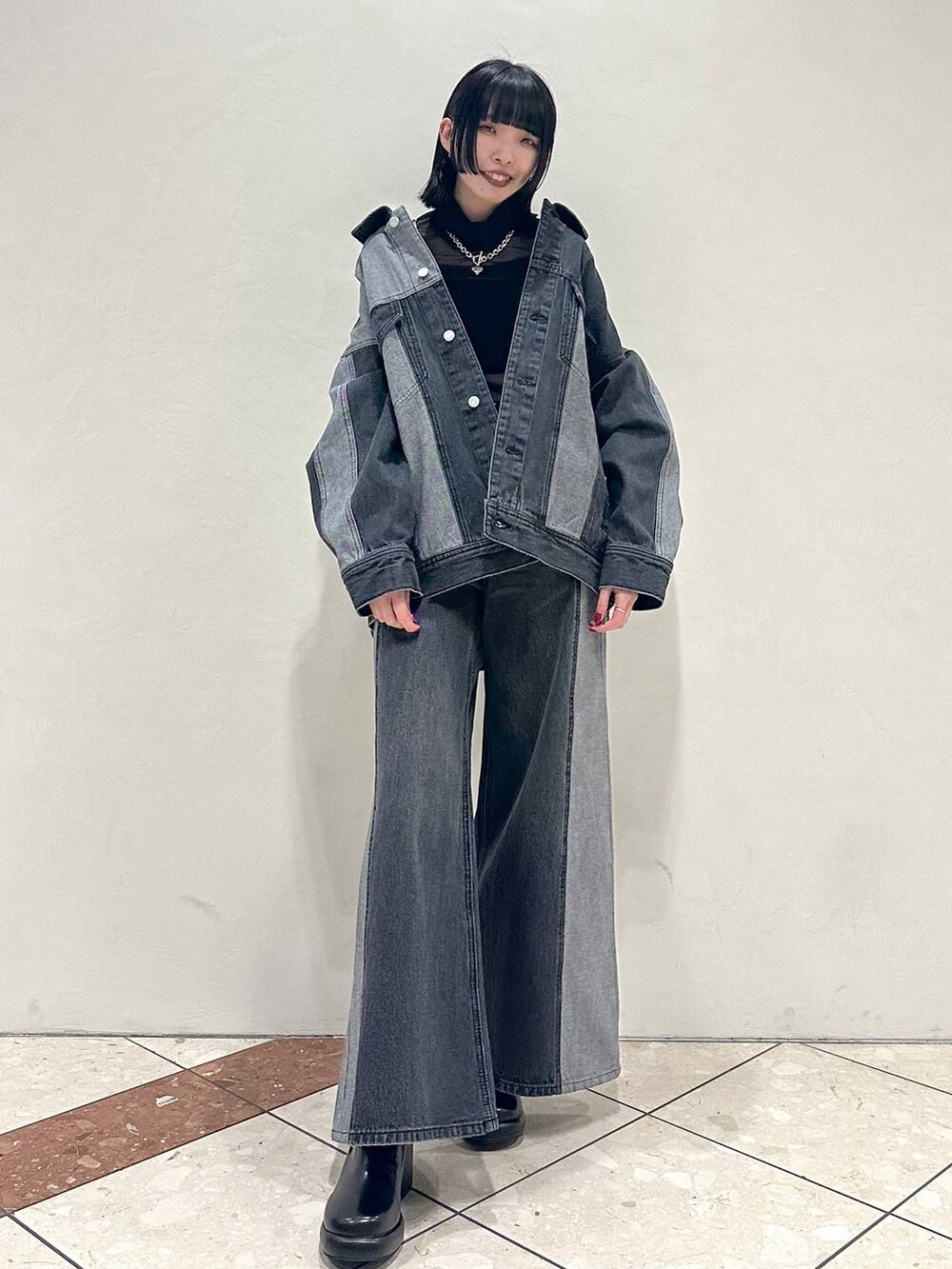 ブラック系のTシャツ/カットソー、ブラック系のデニムジャケット、ブラック系のブーツを着用したレディースの冬コーディネートの2枚目の写真