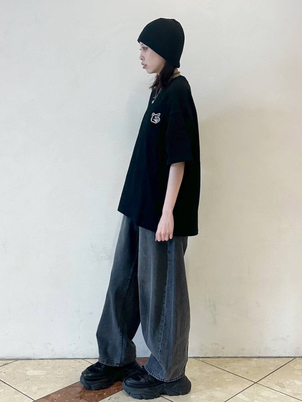 ブラック系のスニーカー、ブラック系のデニムパンツ、ブラック系のTシャツ/カットソーを着用したレディースの春コーディネートの3枚目の写真