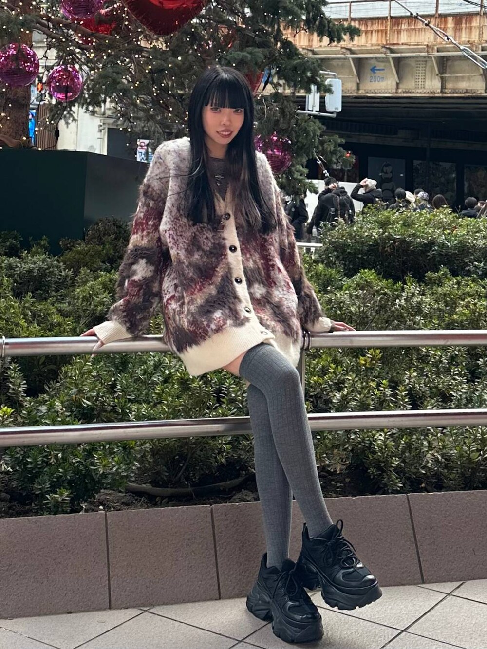 ブラック系のスニーカー、ブラウン系のTシャツ/カットソー、ホワイト系のカーディガン/ボレロを着用したレディースの冬コーディネートの2枚目の写真