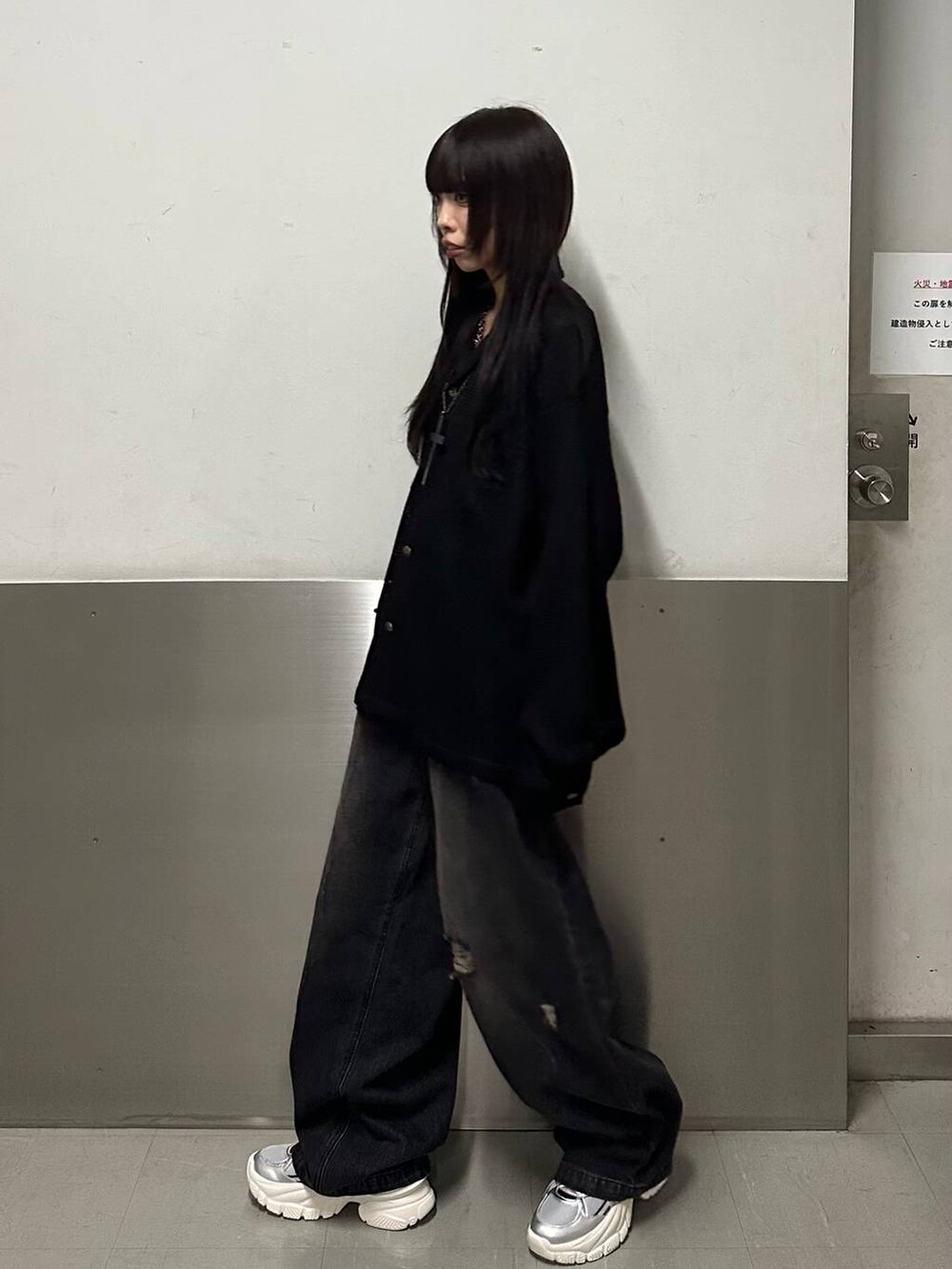 シルバー系のスニーカー、ブラック系のデニムパンツ、ブラック系のシャツ/ブラウスを着用したレディースの秋コーディネートの3枚目の写真