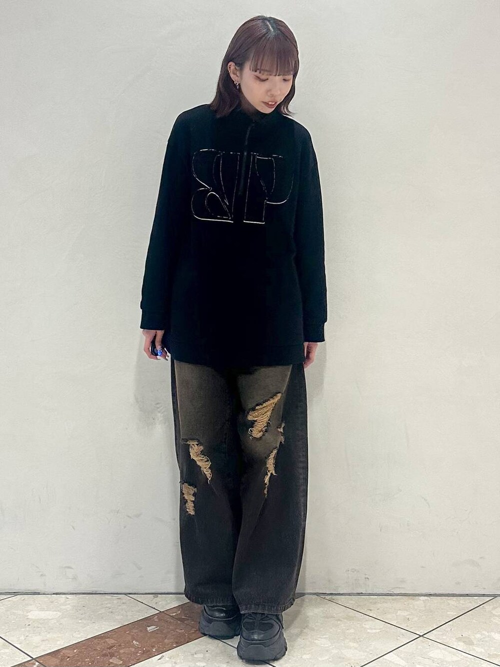 ブラック系のスニーカー、ブラック系のスウェット、ブラック系のデニムパンツを着用したレディースの冬コーディネートの2枚目の写真