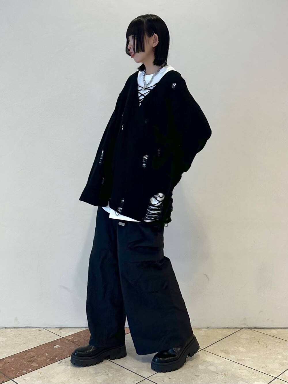 ブラック系のニット/セーター、ブラック系のカーゴパンツ、ブラック系のブーツを着用したレディースの冬コーディネートの3枚目の写真