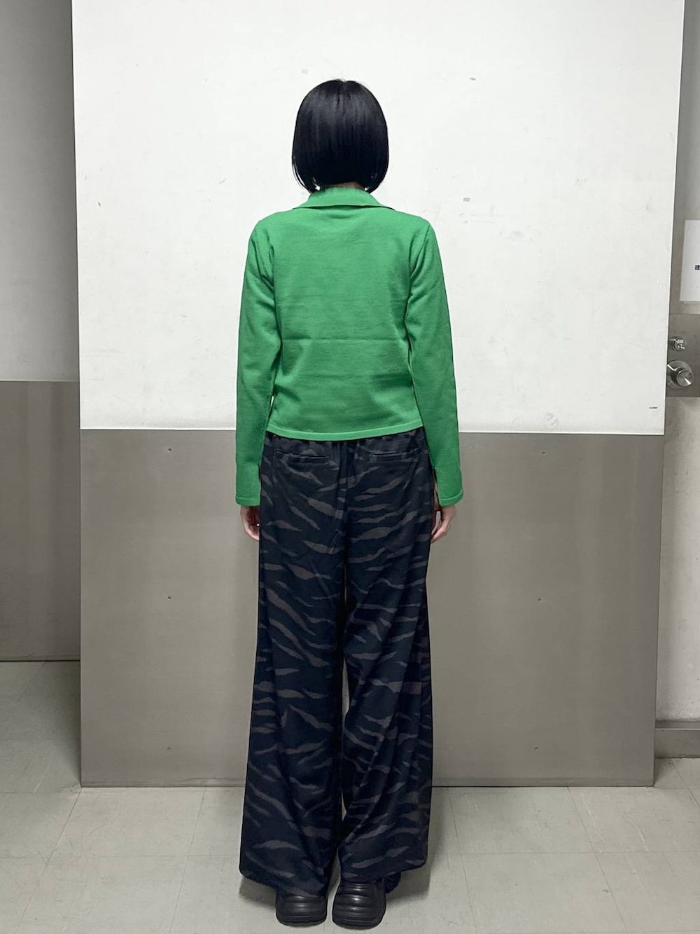 ブラック系のスニーカー、グリーン系のカーディガン/ボレロ、その他のスラックスを着用したレディースの冬コーディネートの4枚目の写真