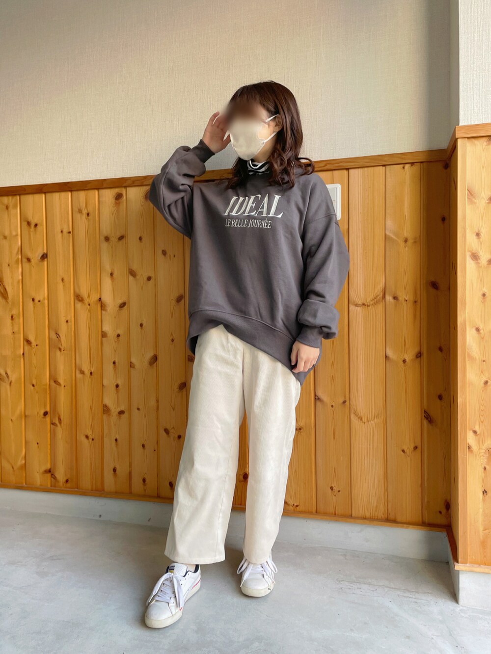 グレー系のスウェット、ホワイト系のパンツ、ホワイト系のスニーカーを着用したレディースの冬コーディネートの2枚目の写真