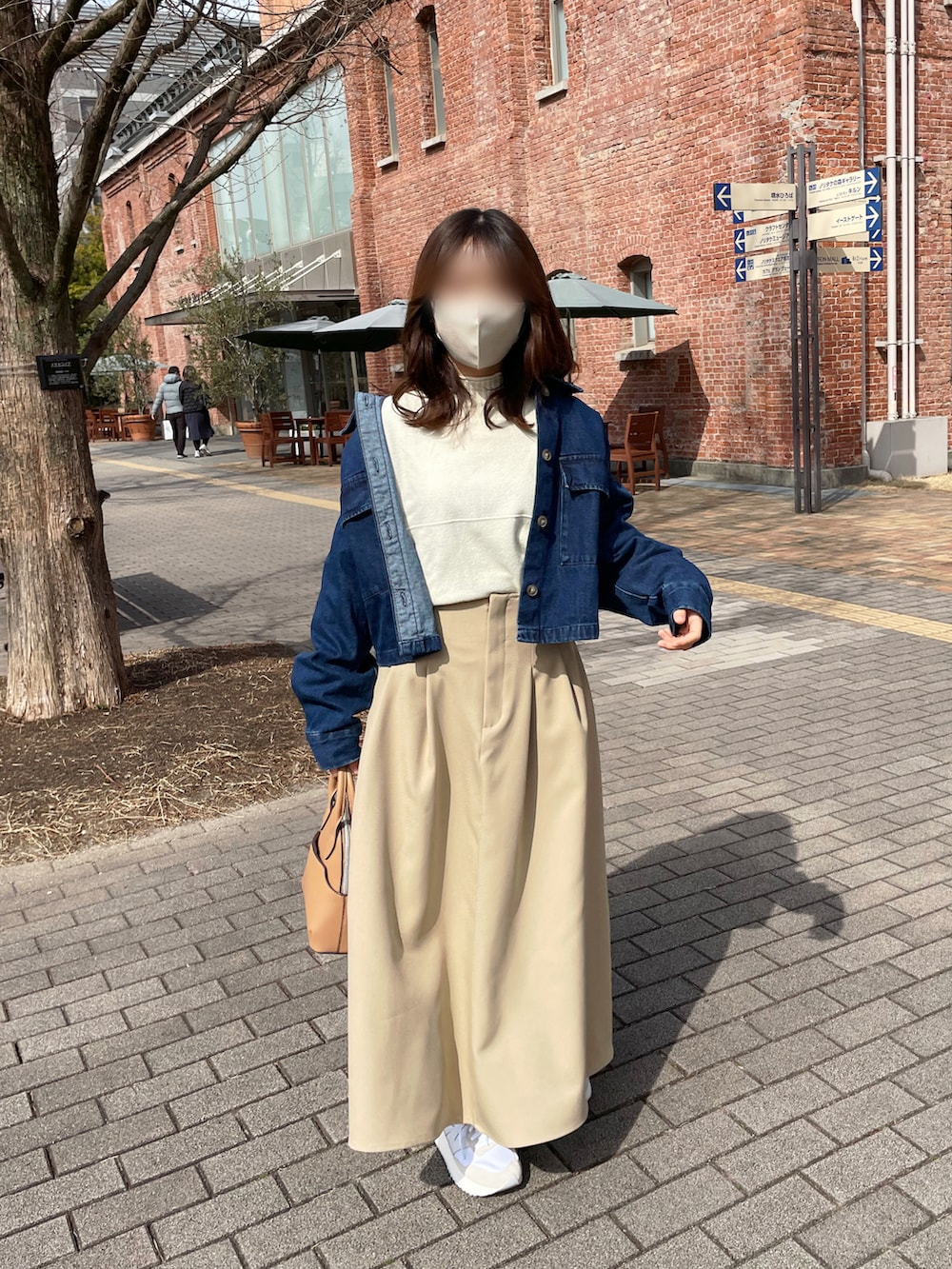 ホワイト系のニット/セーター、ブルー系のデニムジャケット、ベージュ系のスカートを着用したレディースの春コーディネートの2枚目の写真