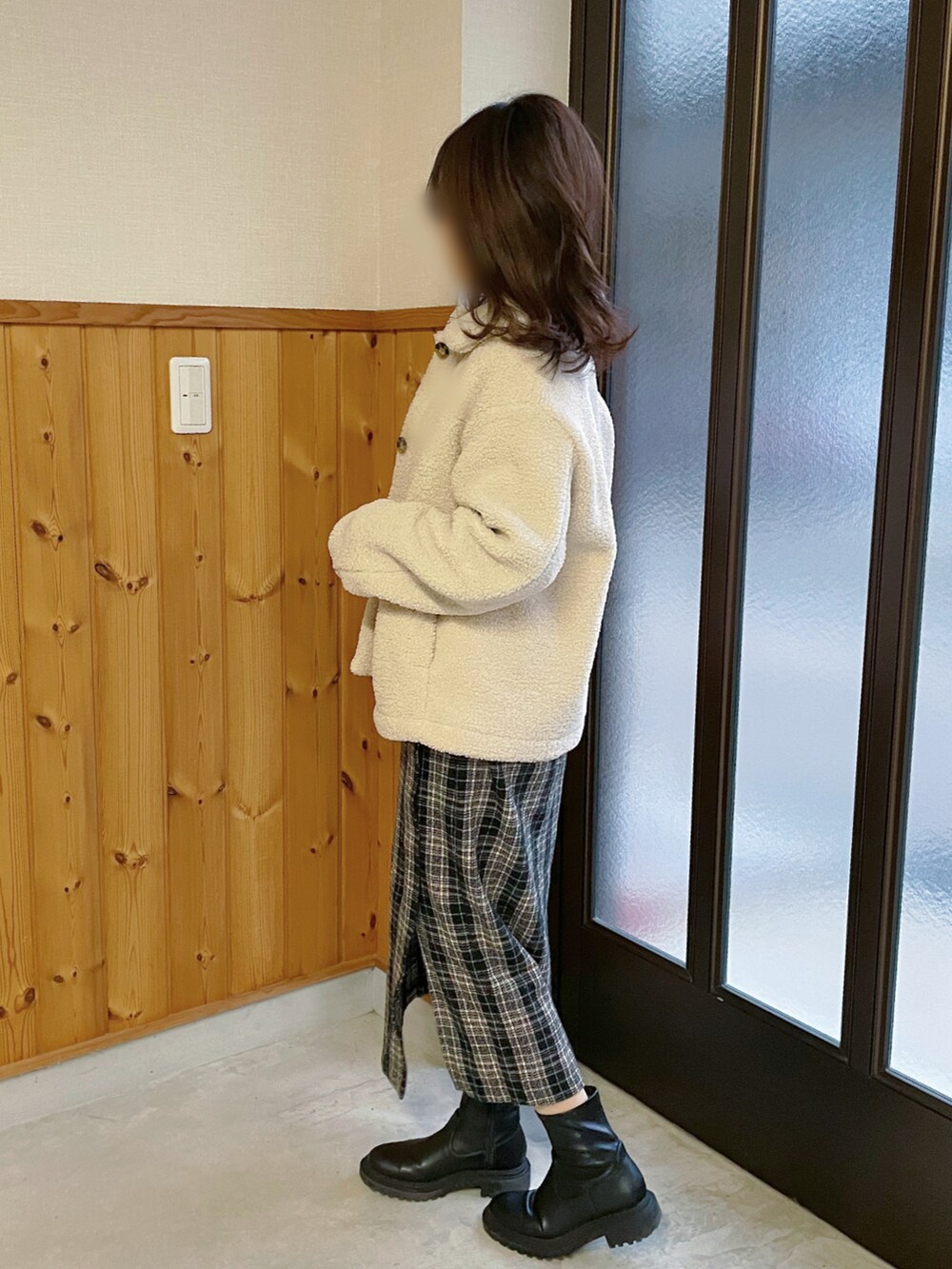 ブラック系のニット/セーター、ブラック系のスカート、ブラック系のブーツを着用したレディースの冬コーディネートの2枚目の写真