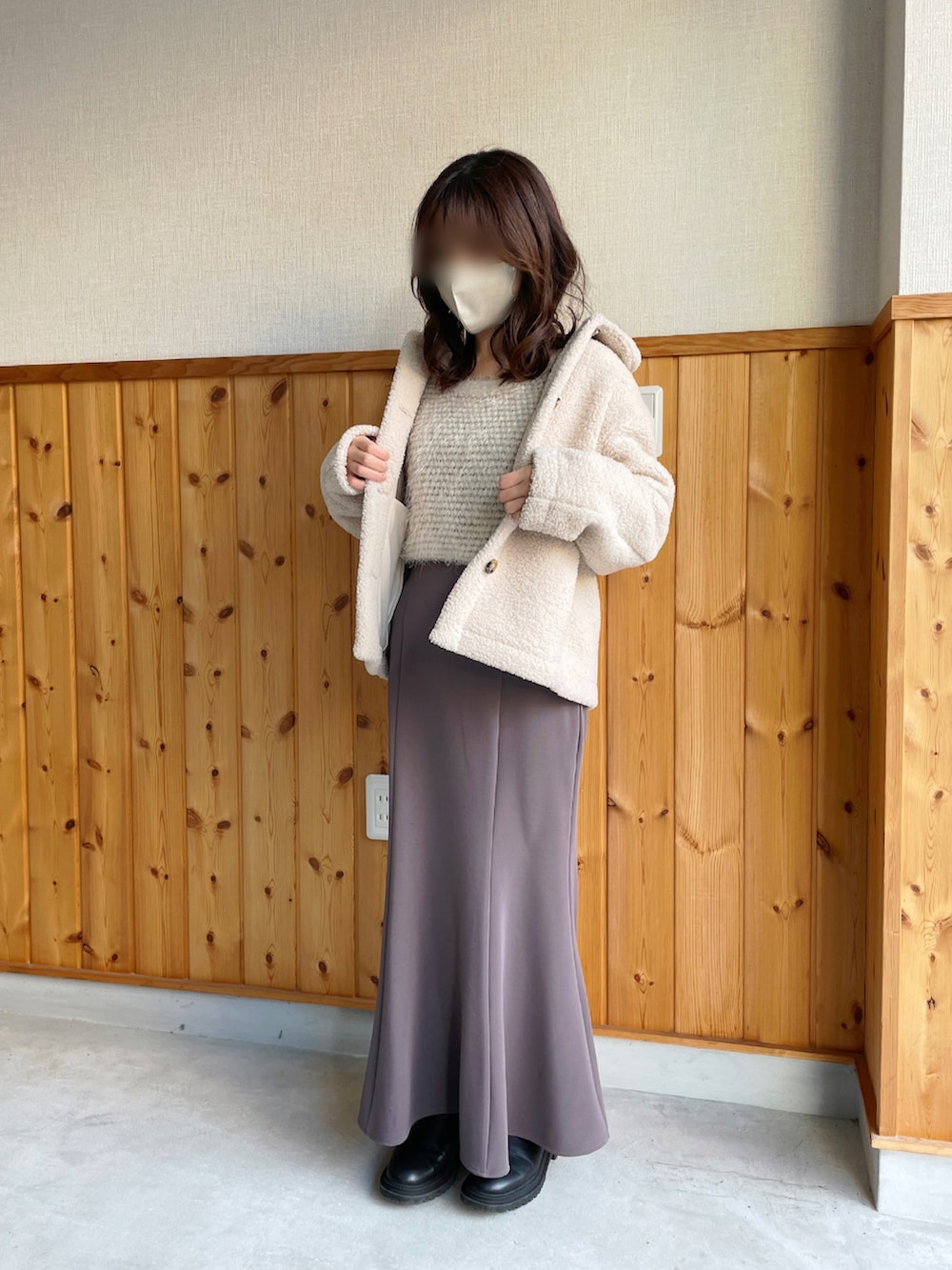 ホワイト系のニット/セーター、ブラウン系のスカート、ブラック系のブーツを着用したレディースの冬コーディネートの2枚目の写真