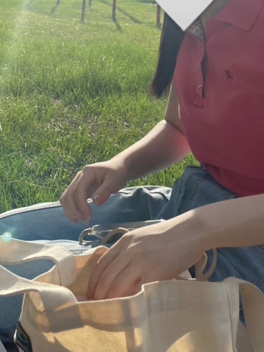 ピンク系のポロシャツ、ブルー系のデニムパンツ、ホワイト系のスニーカーを着用したレディースの秋コーディネートの2枚目の写真