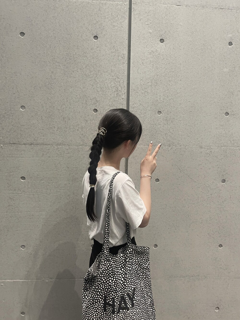 ホワイト系のTシャツ/カットソー、ブラック系のスカート、ホワイト系のスニーカーを着用したレディースの秋コーディネートの2枚目の写真