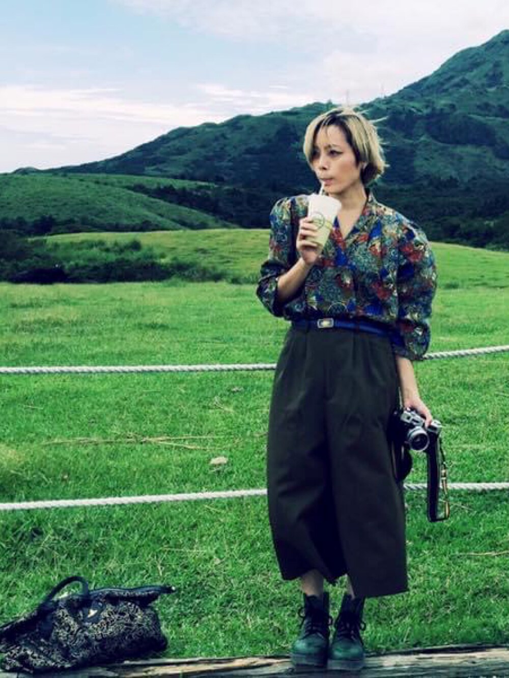 ブラック系のバッグ、グリーン系のシューズ、グリーン系のトップスを着用したレディースの冬コーディネートの2枚目の写真