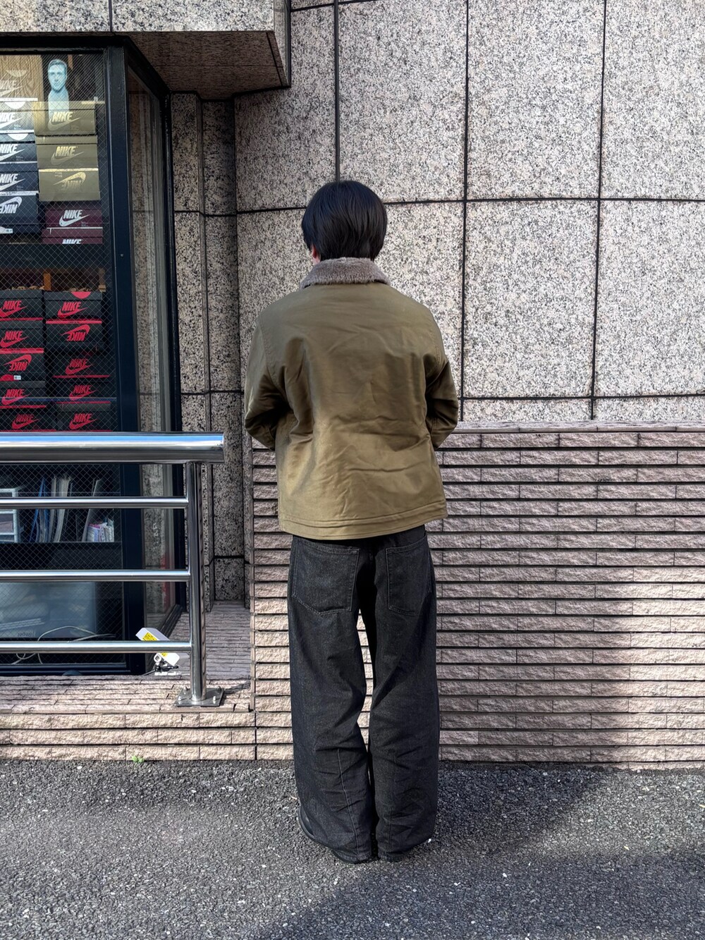 グリーン系のミリタリージャケットを着用したメンズの冬コーディネートの2枚目の写真