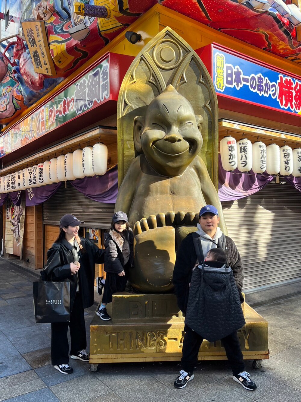 ブラック系のノーカラージャケット、グレー系のパーカー、ブラック系のショルダーバッグを着用したメンズの冬コーディネートの2枚目の写真