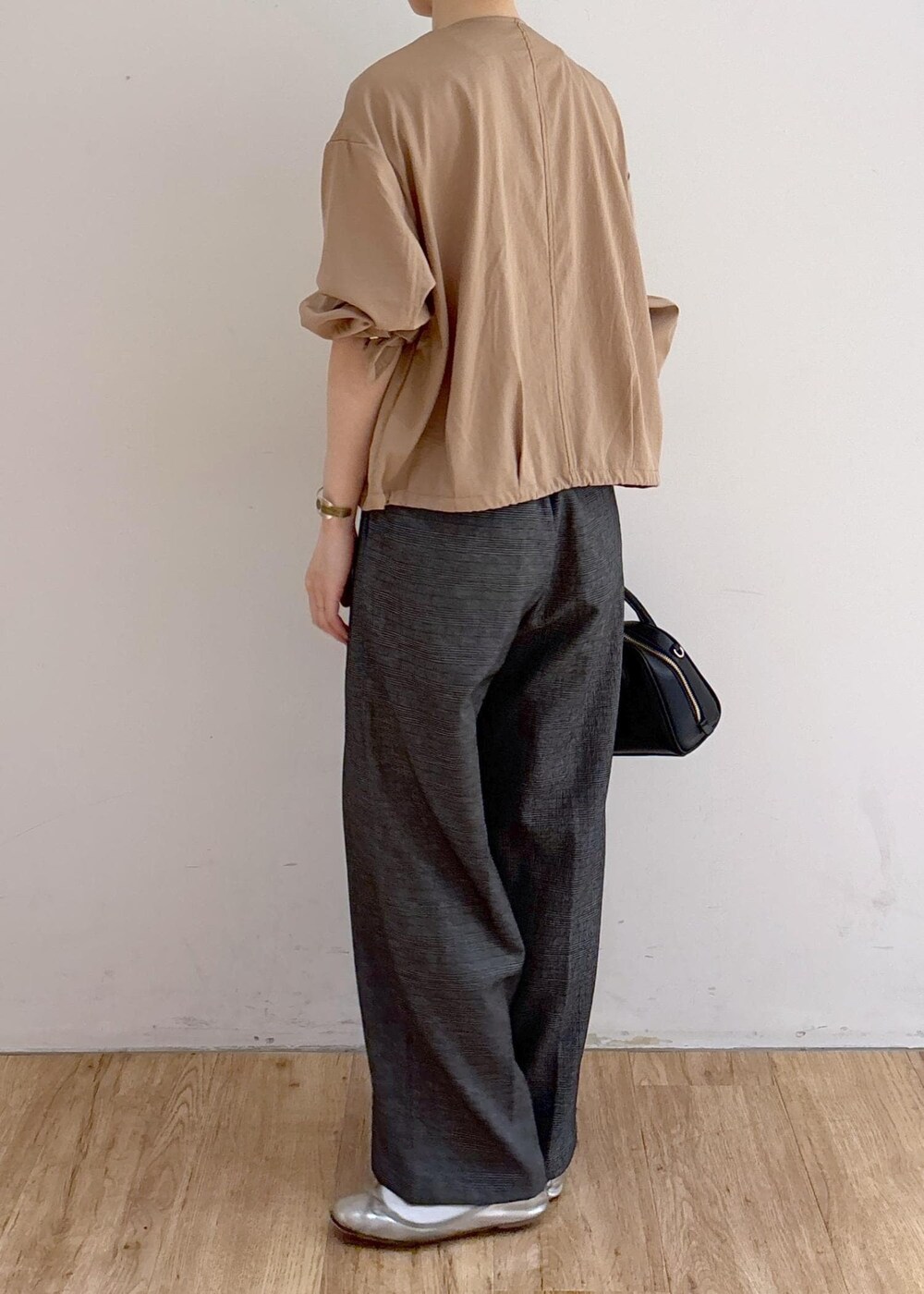 ベージュ系のブルゾン、グレー系のスラックス、ブラック系のショルダーバッグを着用したレディースの秋コーディネートの5枚目の写真