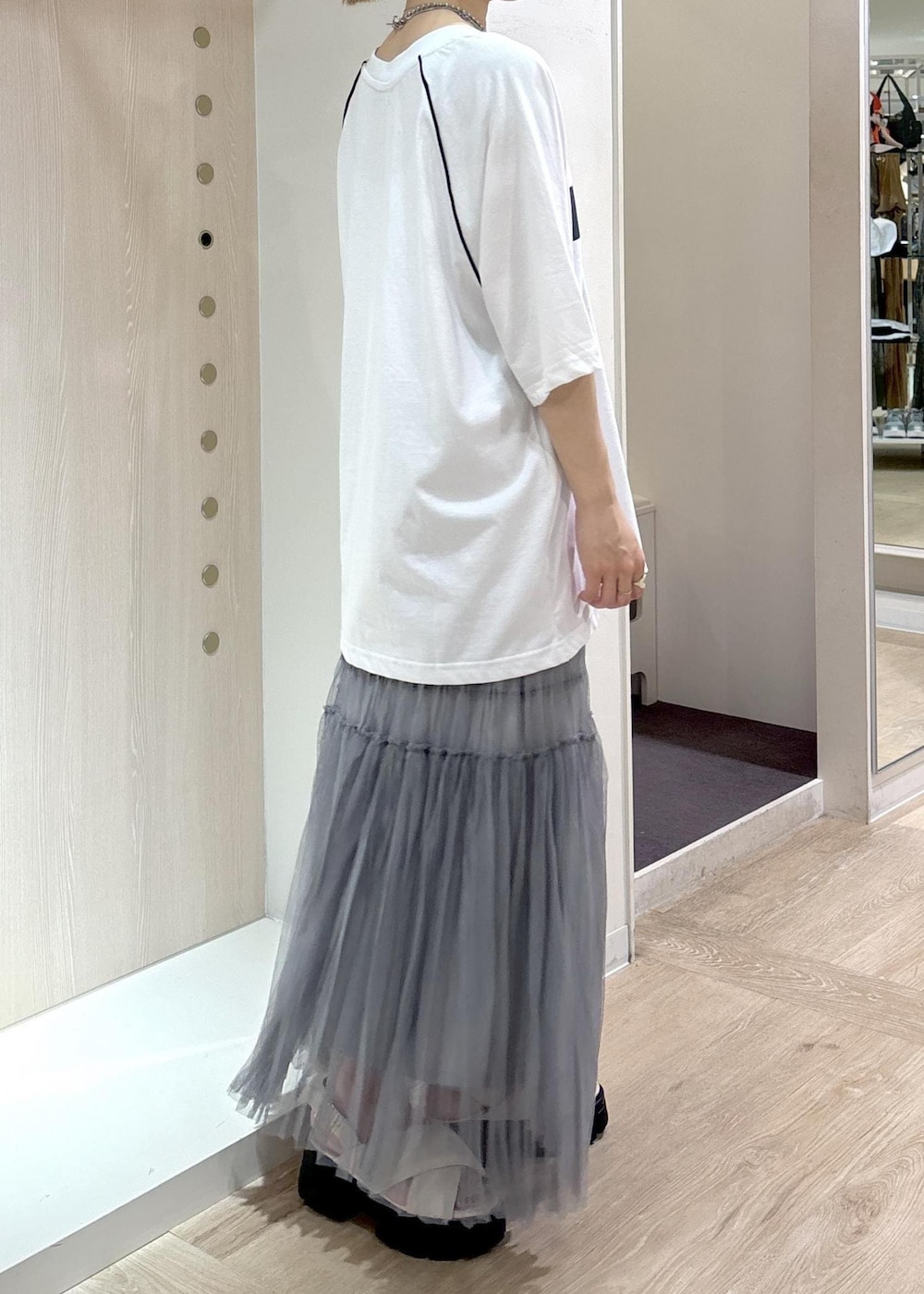 ホワイト系のサンダル、グレー系のスカート、ホワイト系のTシャツ/カットソーを着用したレディースの夏コーディネートの2枚目の写真