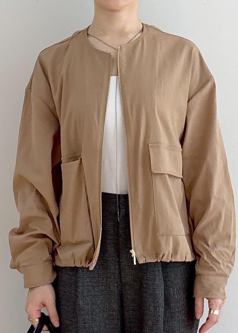 ベージュ系のブルゾン、グレー系のスラックス、ブラック系のショルダーバッグを着用したレディースの秋コーディネートの7枚目の写真