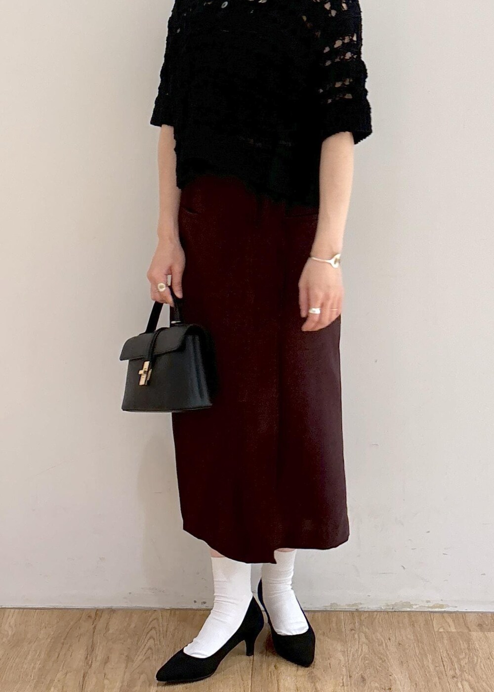 ブラック系のパンプス、ホワイト系のキャミソール、ブラック系のショルダーバッグを着用したレディースの夏コーディネートの6枚目の写真